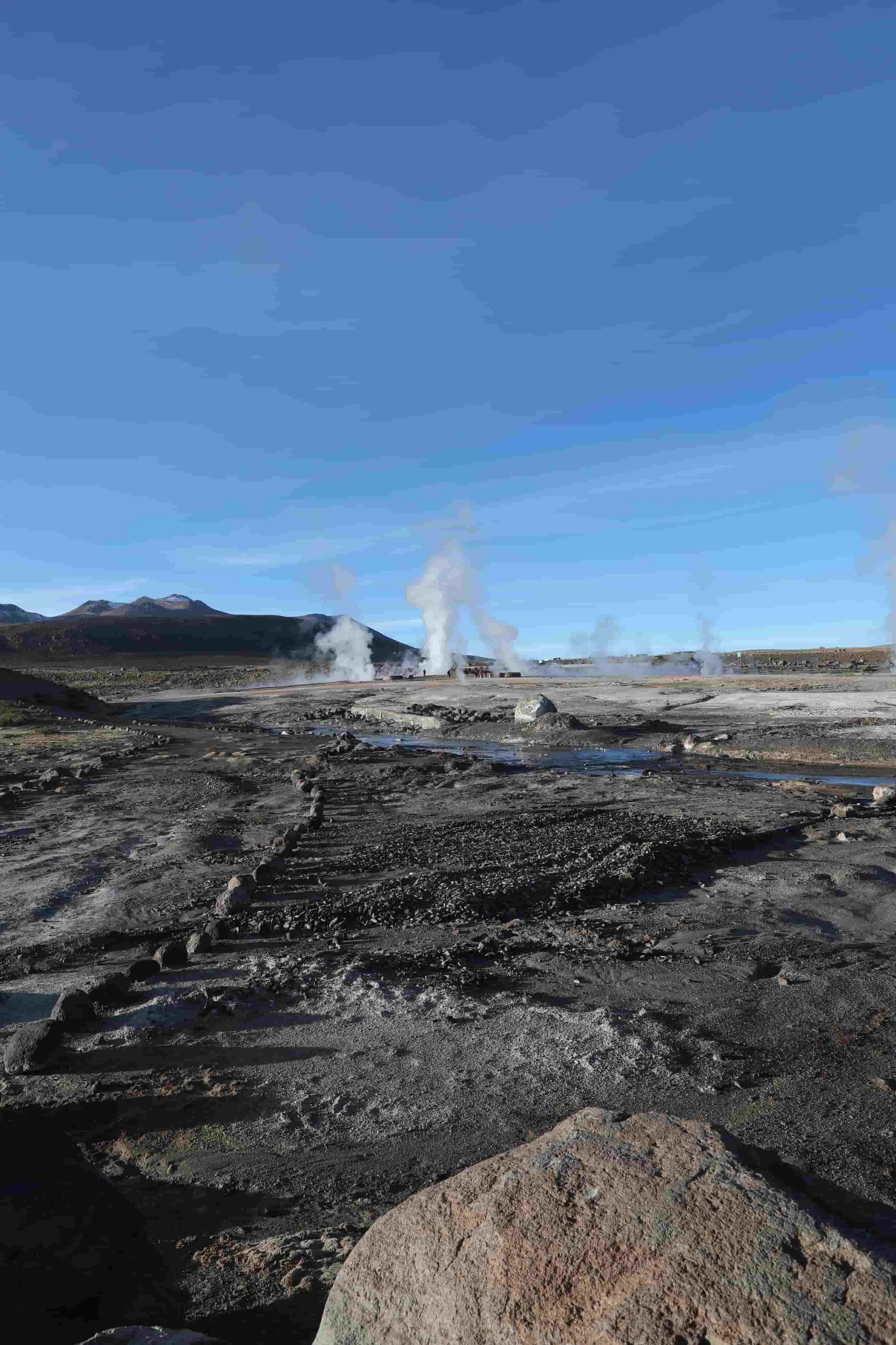 Panoramic view of El Tatio Geysers in Chile, with geothermal steam rising across the high-altitude Andes.