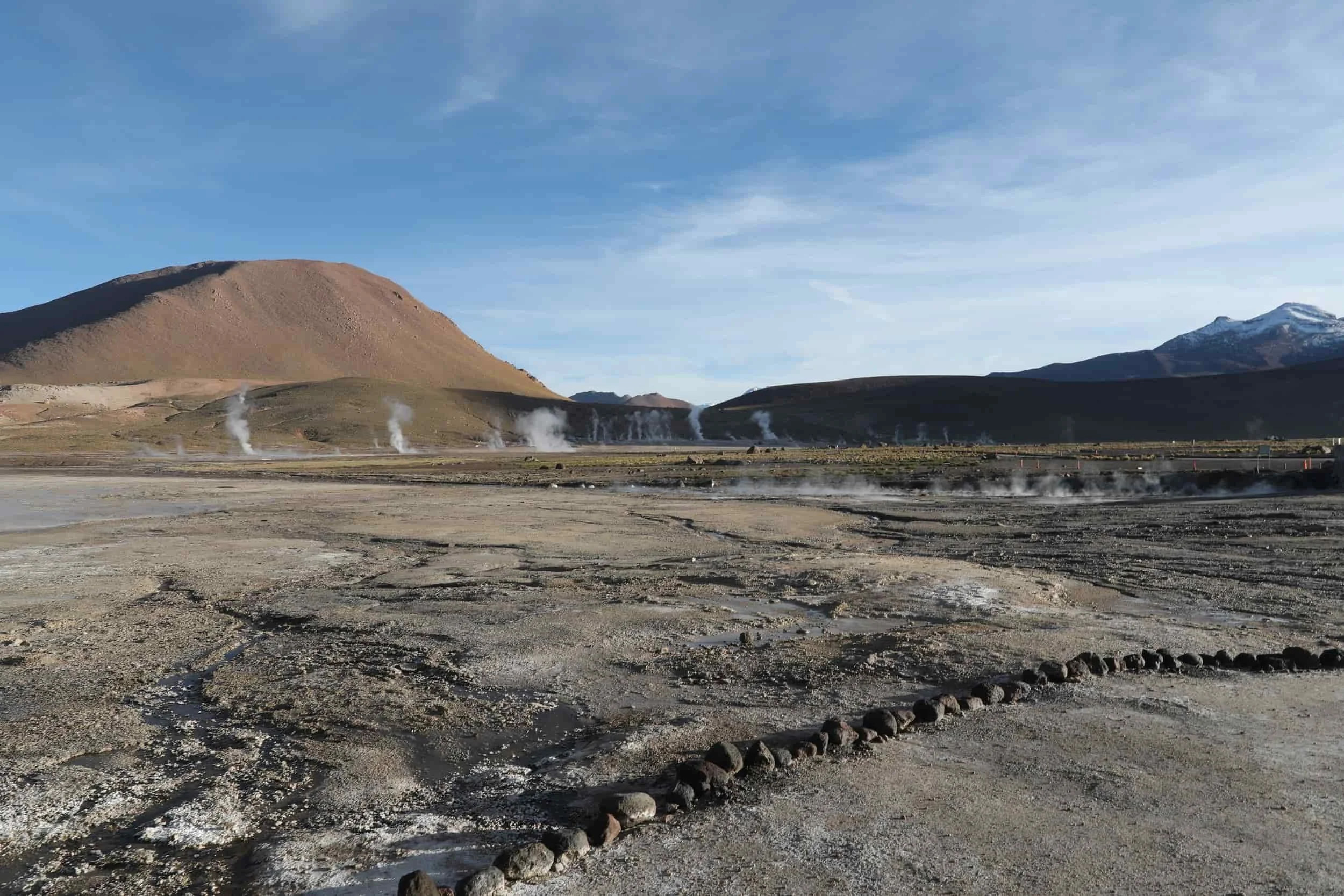 Panoramic view of El Tatio Geysers in Chile, with geothermal steam rising across the high-altitude Andes.