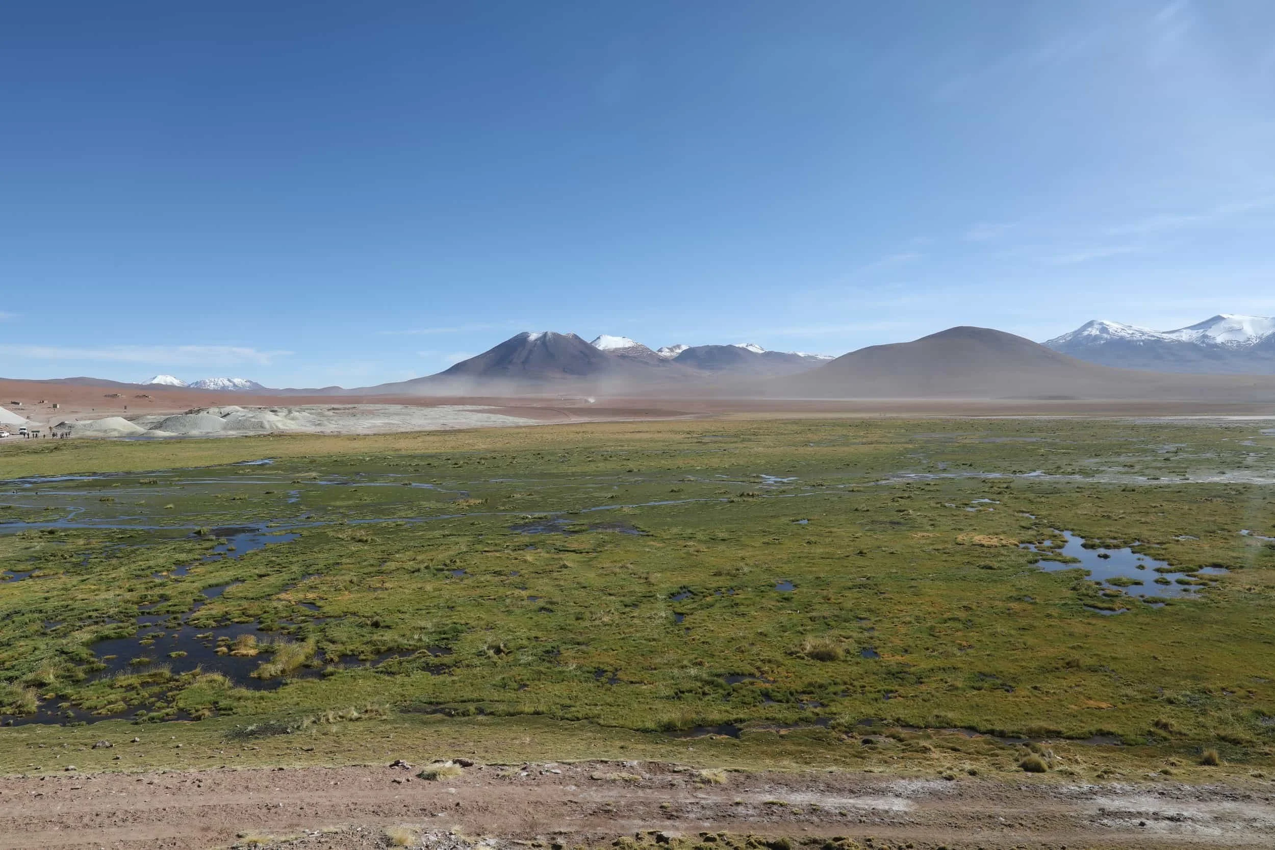 The Putana River winding through green Andean wetlands surrounded by volcanic mountains in northern Chile.