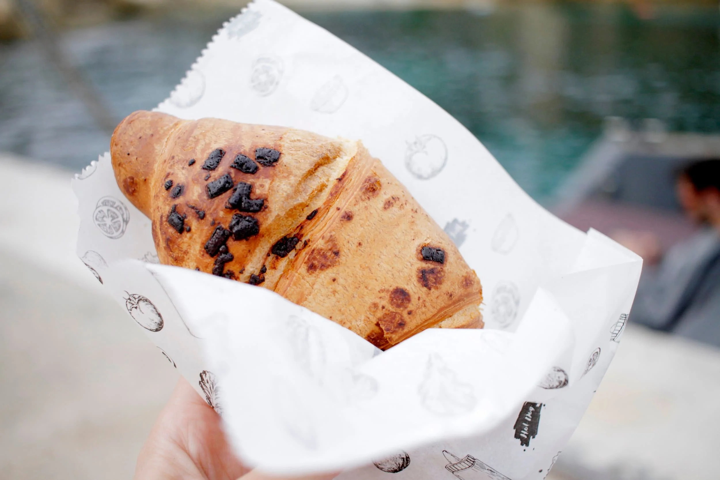 Hand holding chocolate croissant 