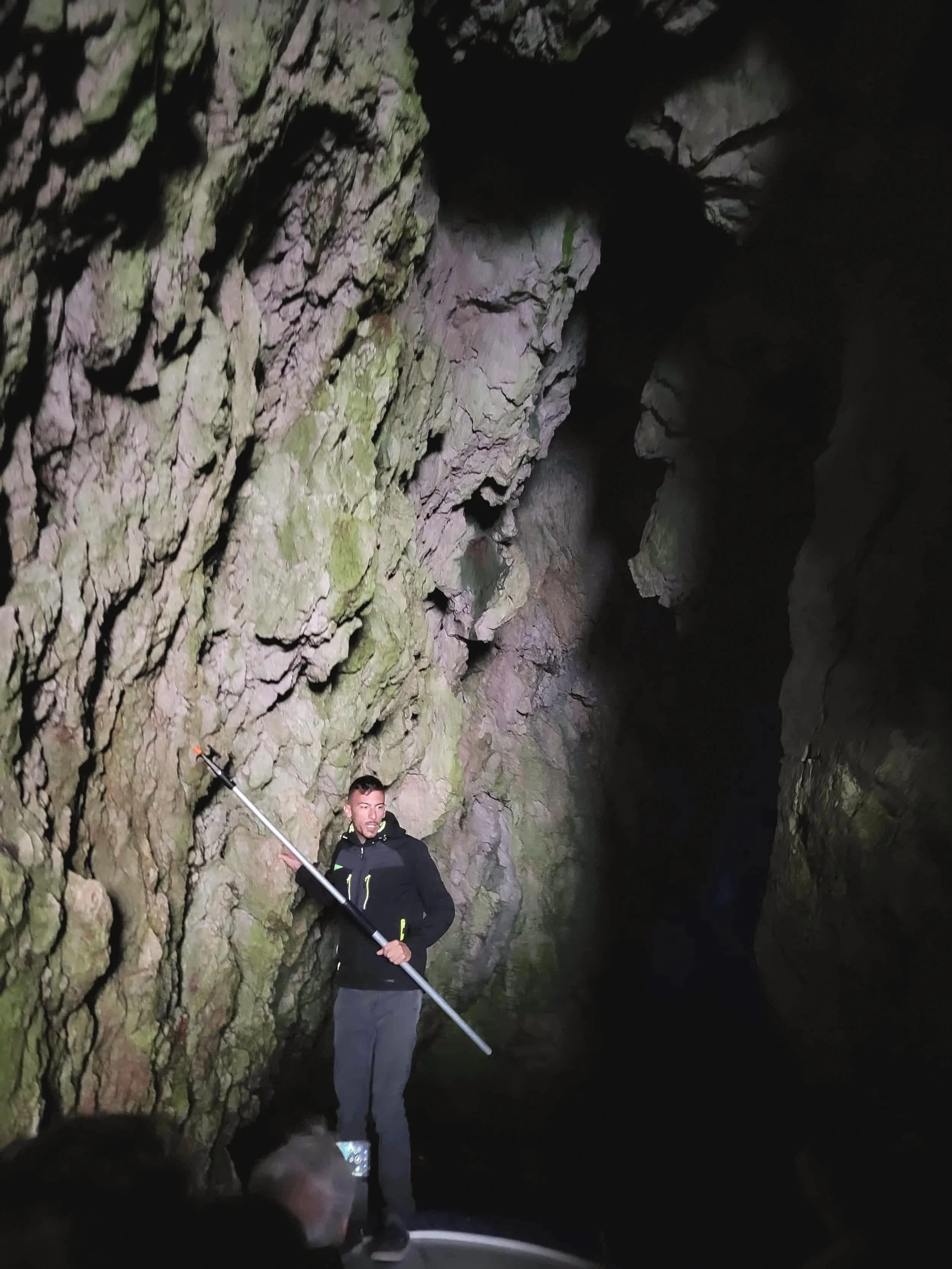 Man guiding boat in Blue Cave against rocky walls