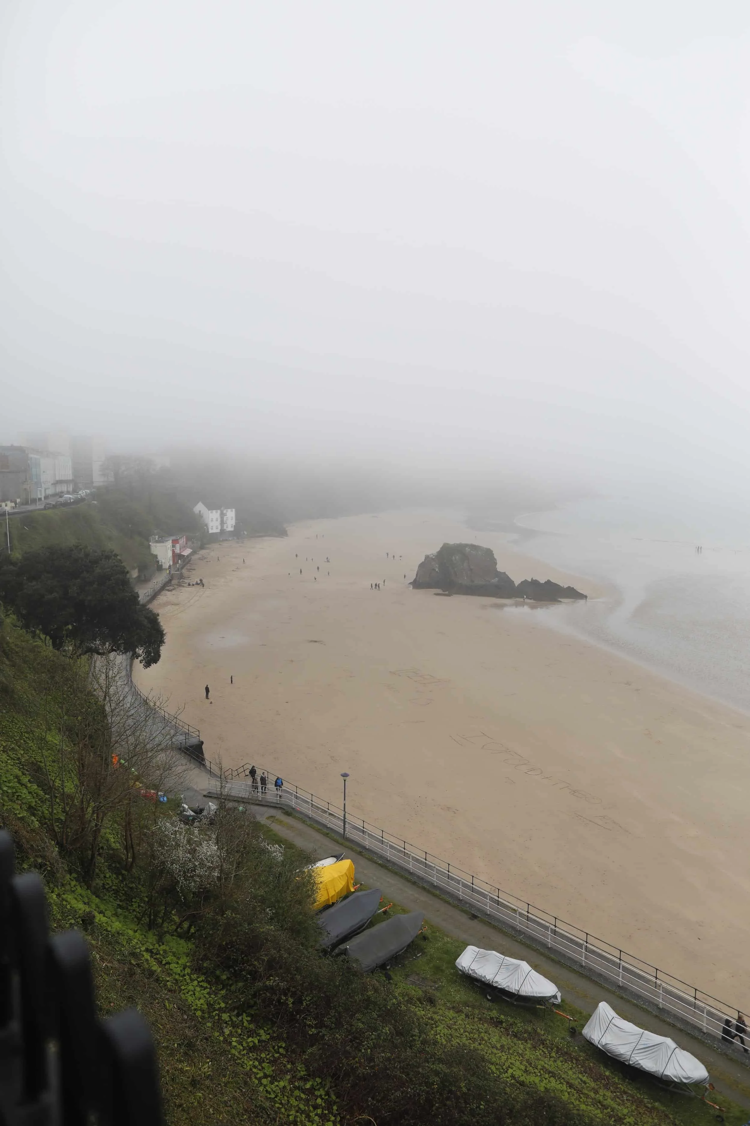 Views from above of the foggy beach and bay in Tenby Wales