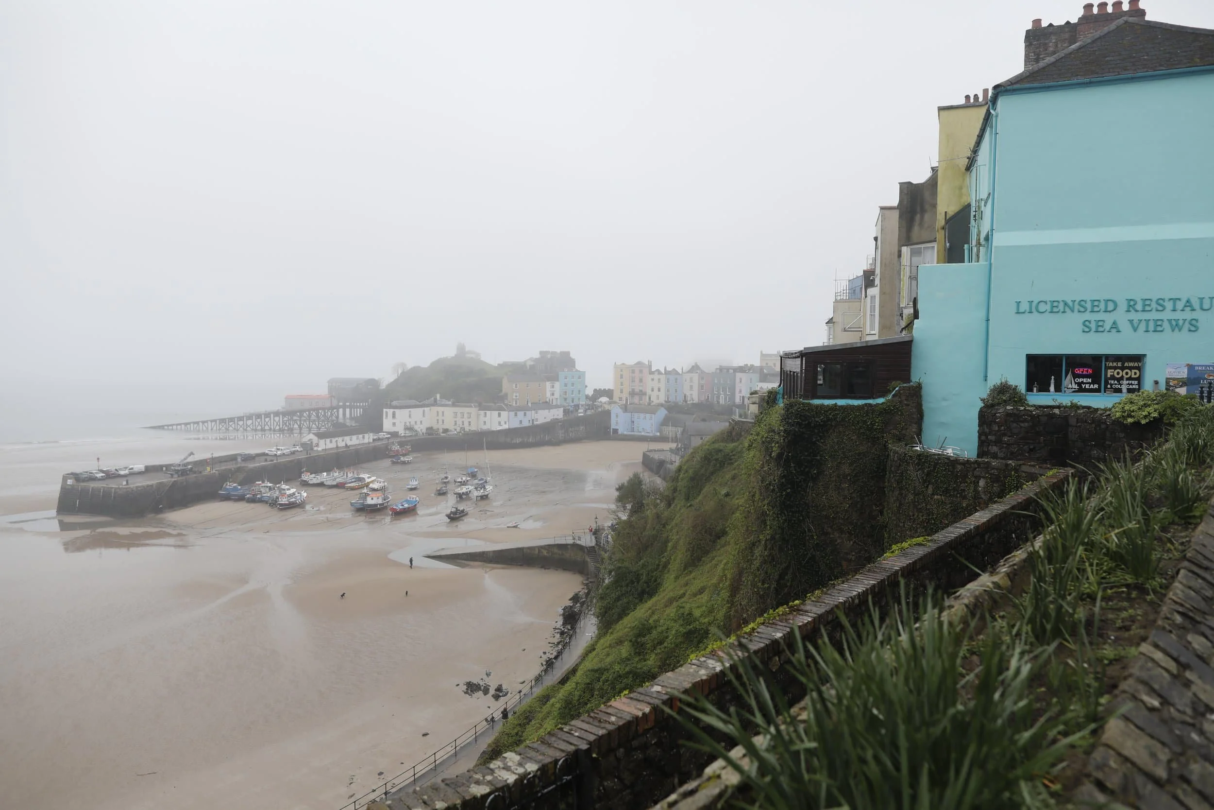 Views from above of the foggy beach and bay in Tenby Wales