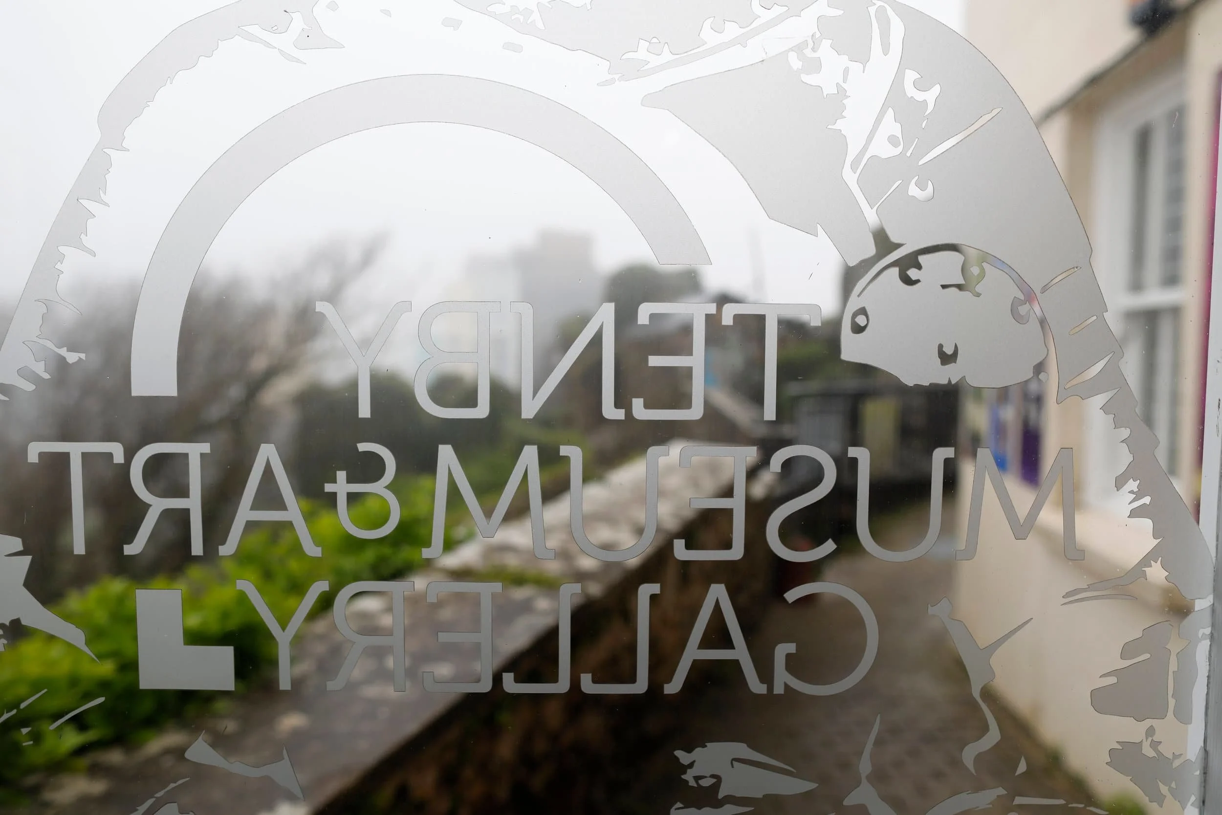 Signage on glass door at Tenby Museum &amp; Art Gallery in Tenby Wales
