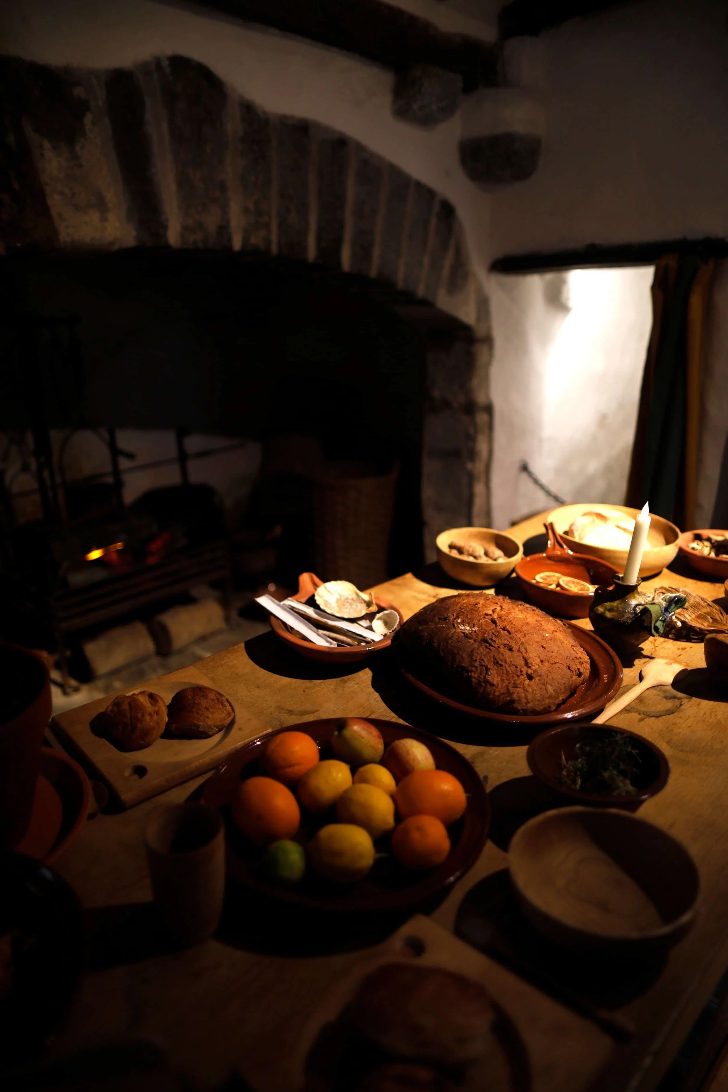 Interior of the Tudor Merchant's House in Tenby Wales, table laid out with food and fireplace in background