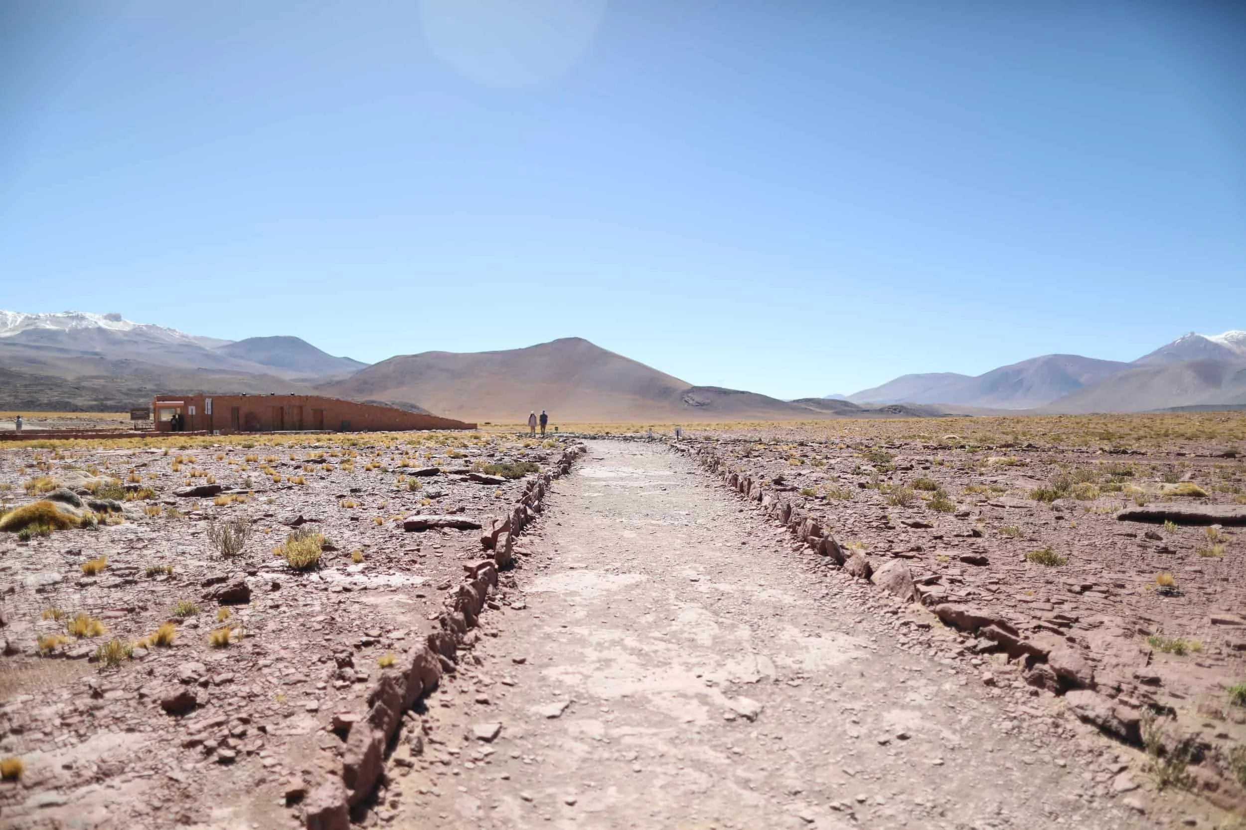 Desert with red rocks and mountains in the distance at Piedras Rojas in Atacama Desert in Chile