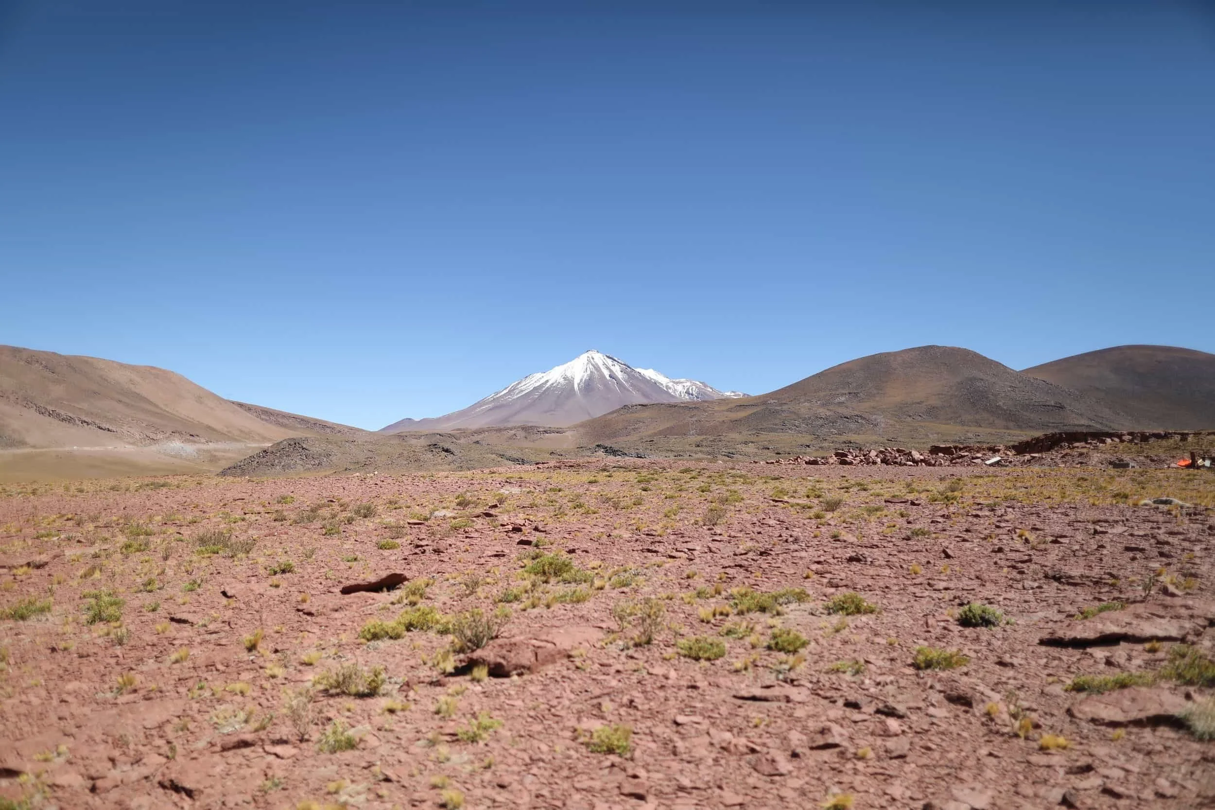 Desert with red rocks and mountains in the distance at Piedras Rojas in Atacama Desert in Chile