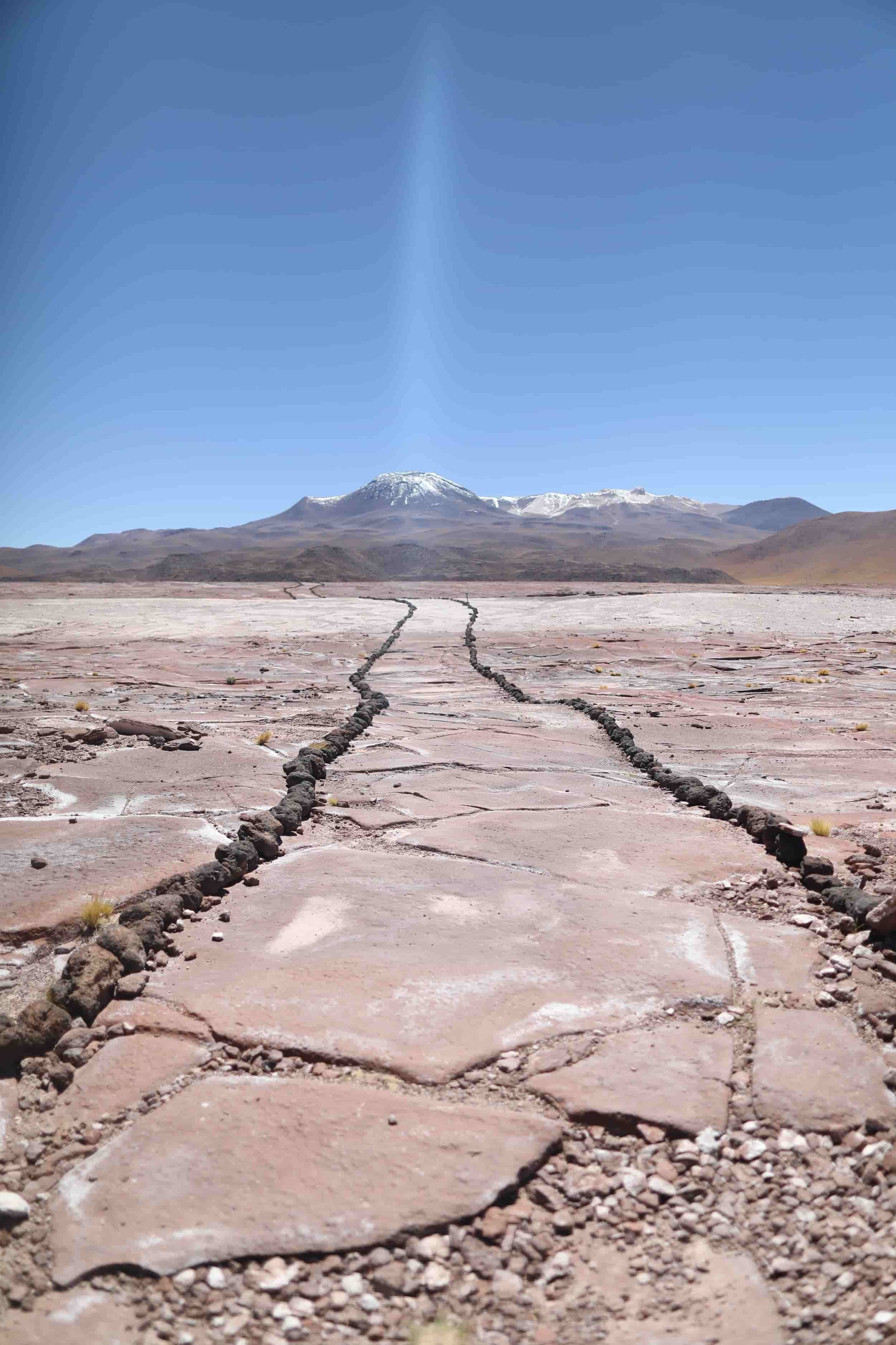 Desert with red rocks and mountains in the distance at Piedras Rojas in Atacama Desert in Chile