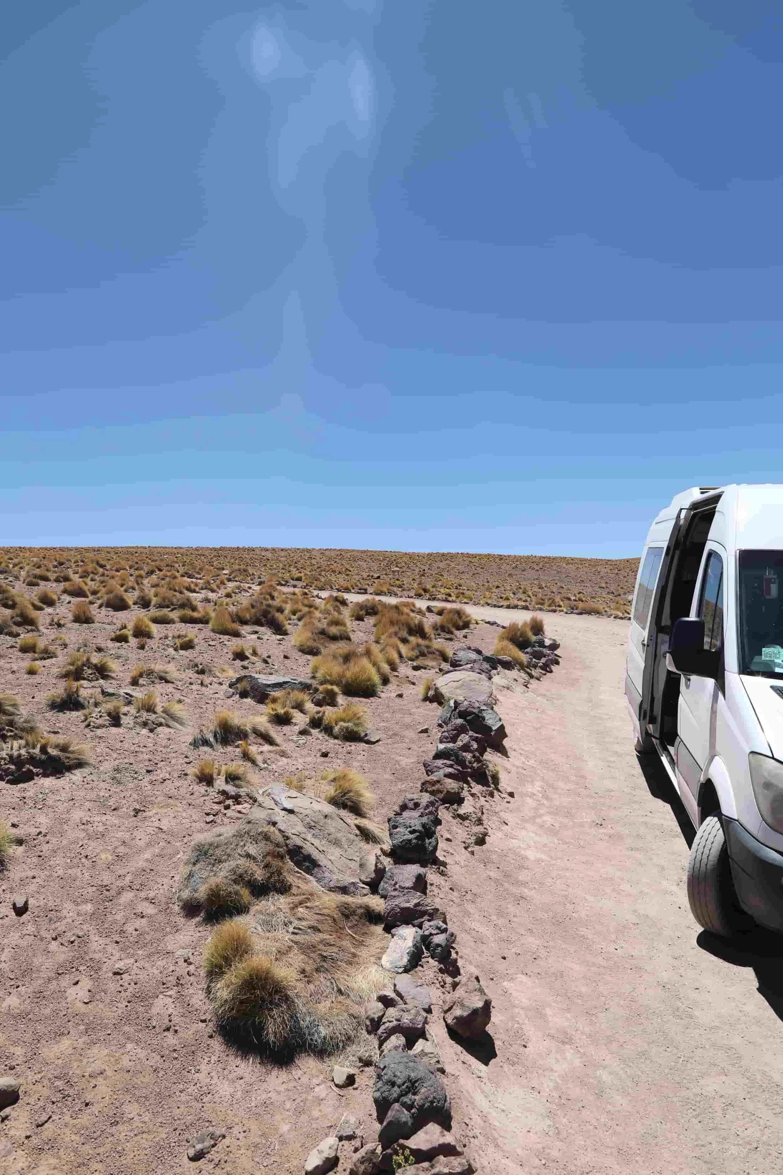 Atacama desert with red sand and rocks with a white van just out of image