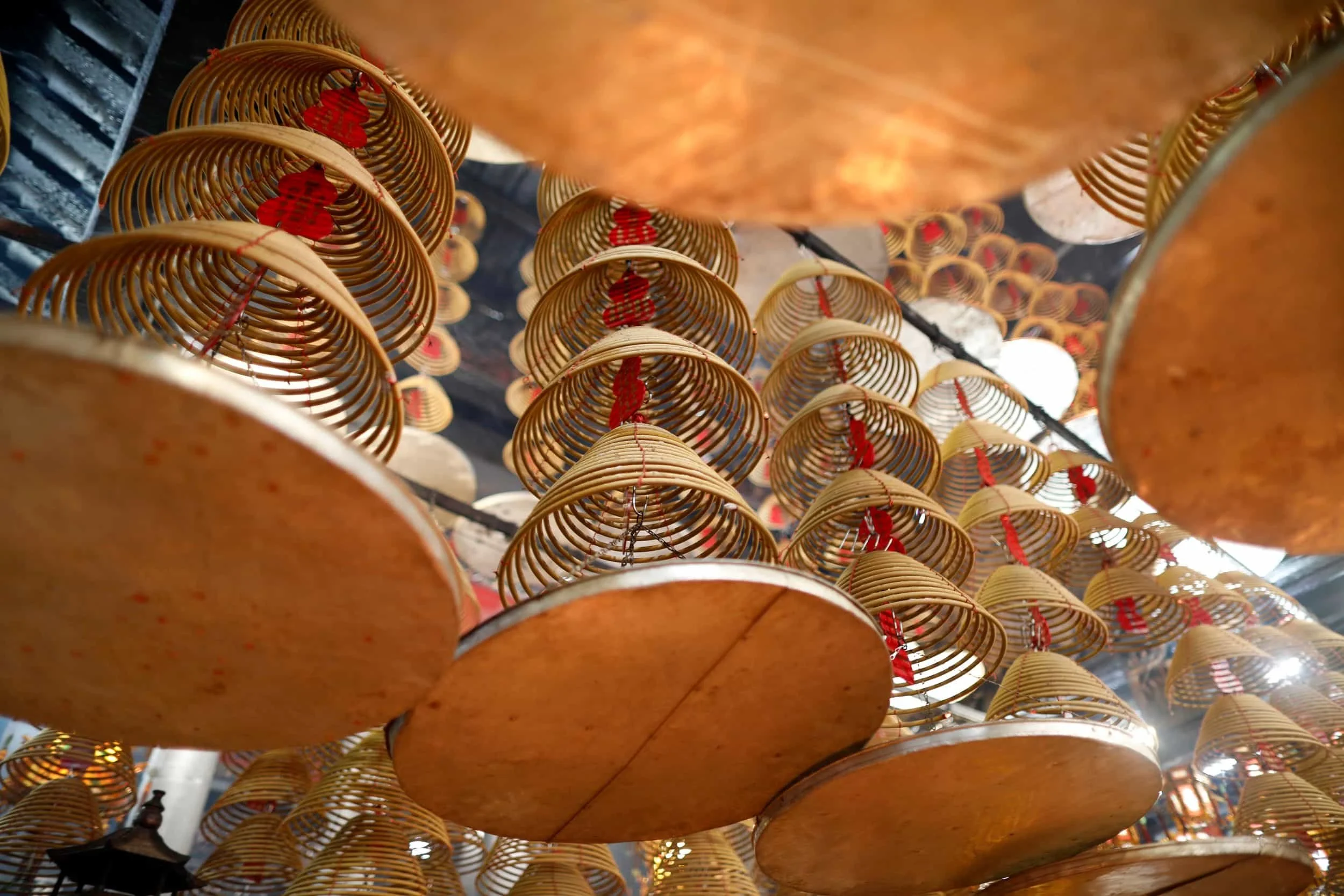 Numerous hanging incense with red ribbons, viewed from below in Hong Kong.