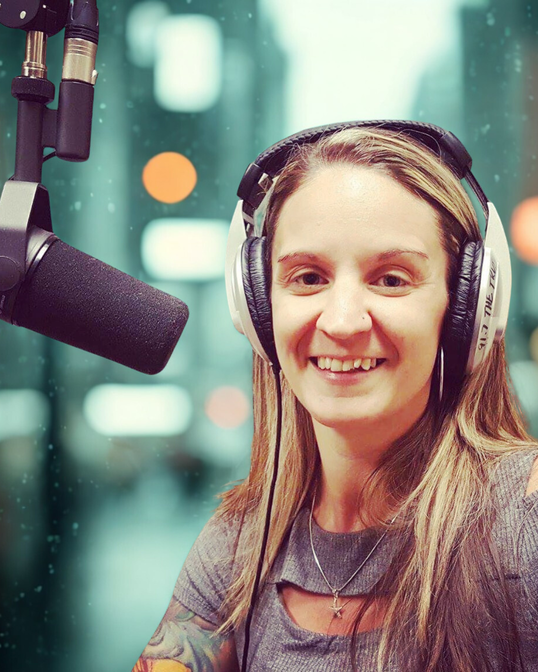 A young woman with long hair is wearing headphones and smiling at a microphone in a recording studio.