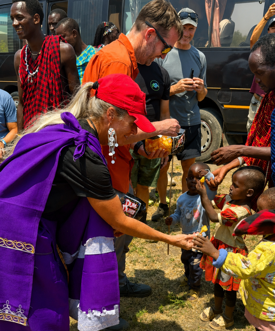 Members of Dealers of Hope Foundation giving to young children in a Tanzanian village.