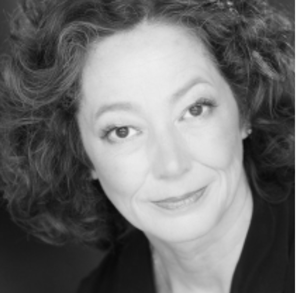 Black and white portrait of a woman with curly hair, smiling gently at the camera.