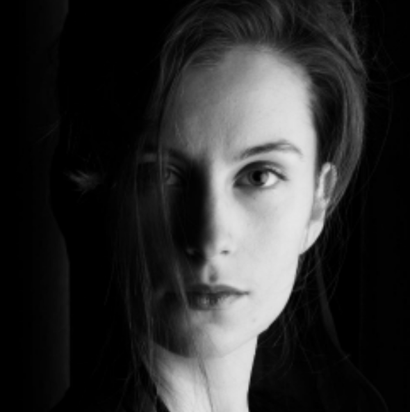 Black and white portrait of a young woman with one eye covered by hair, looking directly at the camera.