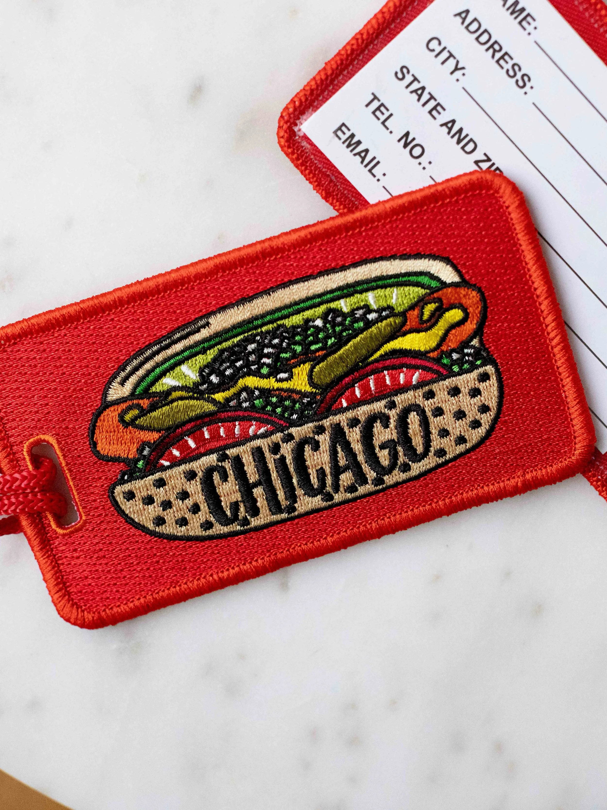A moment for my new favorite luggage tag 🧳✈️ What do we think?! &hearts;️ 

If you want to sport your love of Chicago as you travel, I think I have the perfect new Chicago-style souvenir for you!?

Fully embroidered Chicago-style hot dog design on t