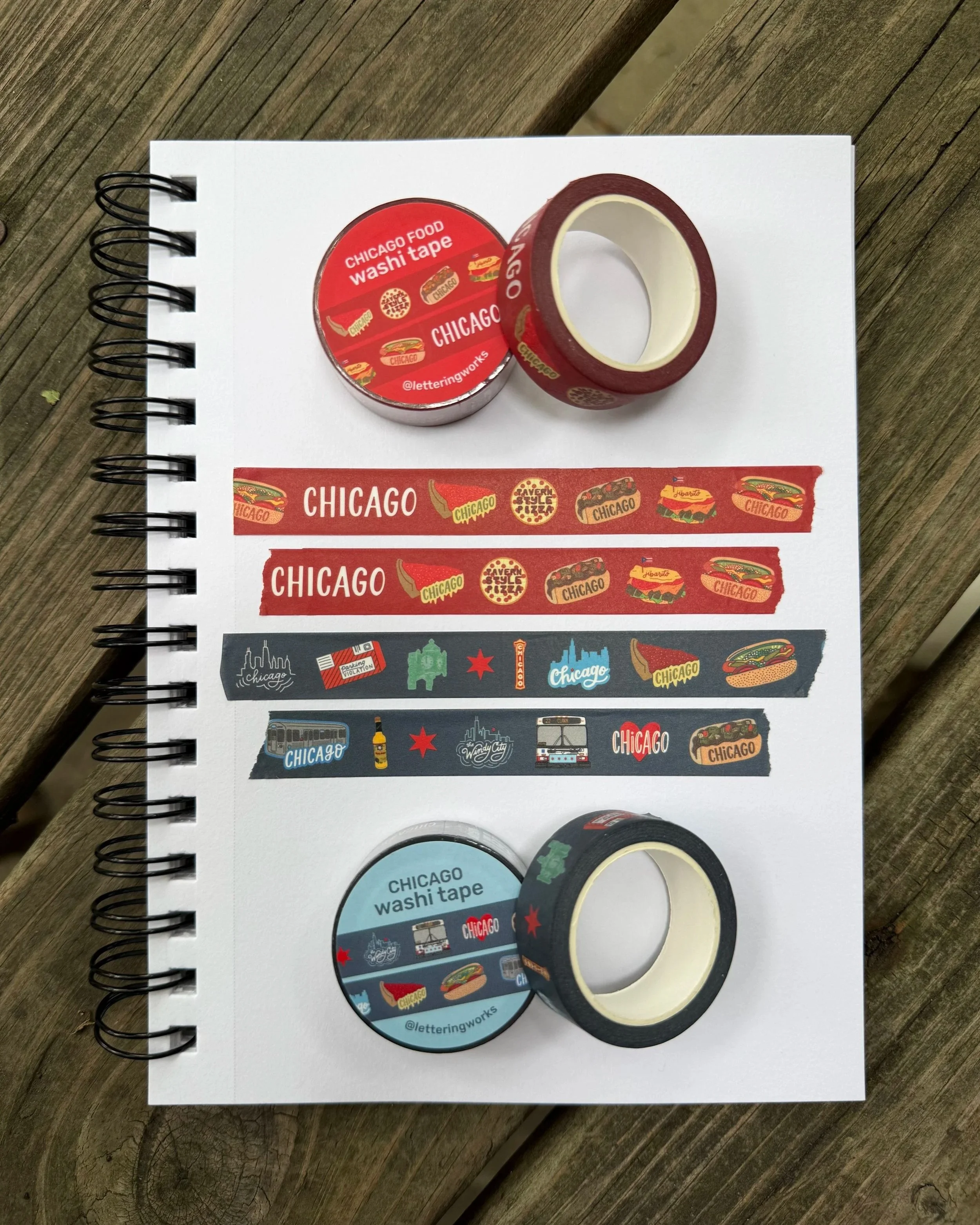 Chicago Food and Chicago Icons washi tape by lettering works is displayed on a sketchbook. There are torn pieces of the tape spread across the page to show the variety of Chicago illustrations included.
