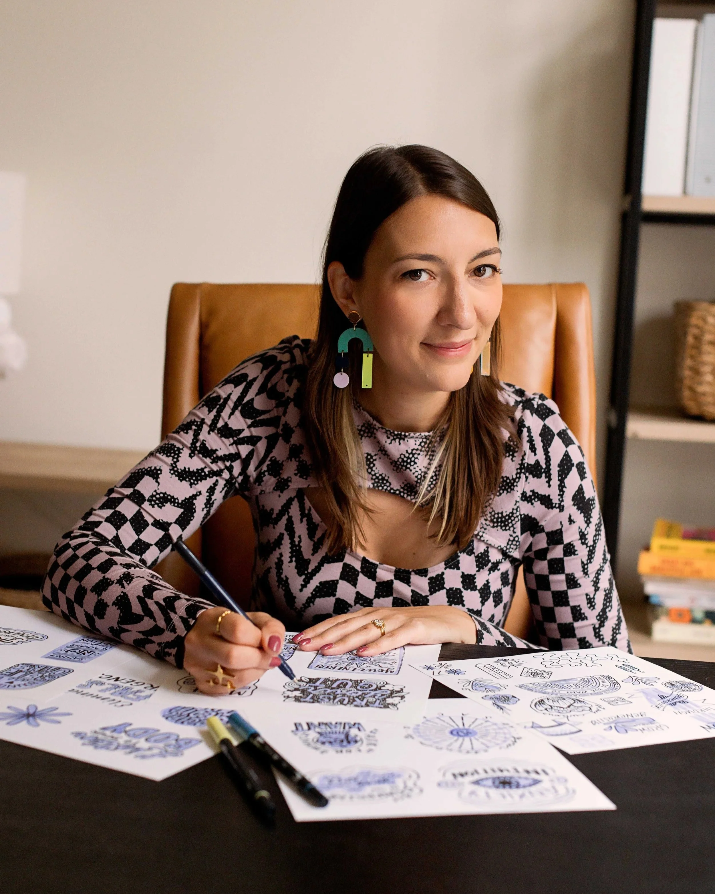 Headshot of Lettering Artist Chelsie Tamms sketching sticker designs