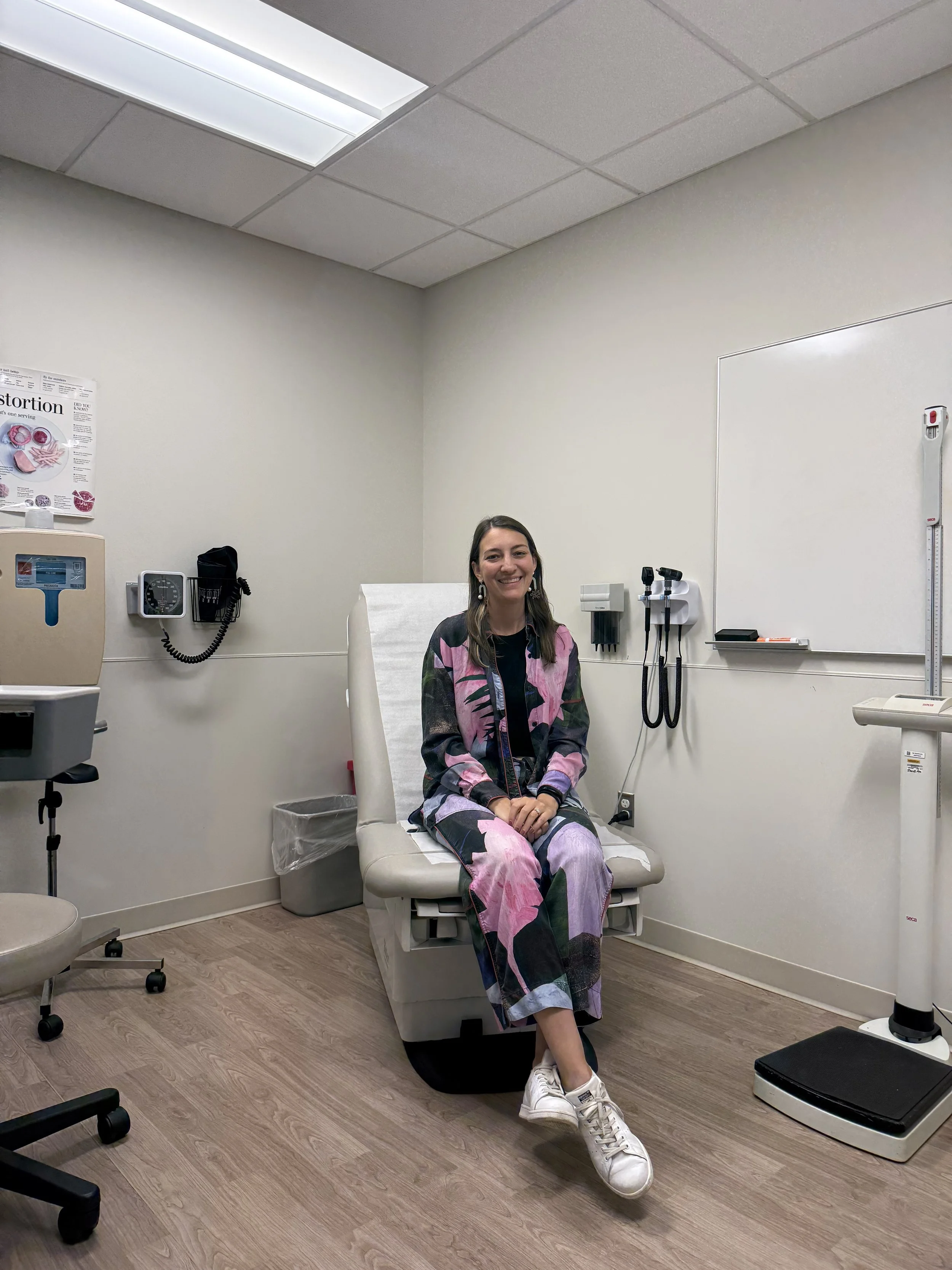 Chelsie sits on a medical examination table at her annual nephrologist appointment at Northwestern Hospital