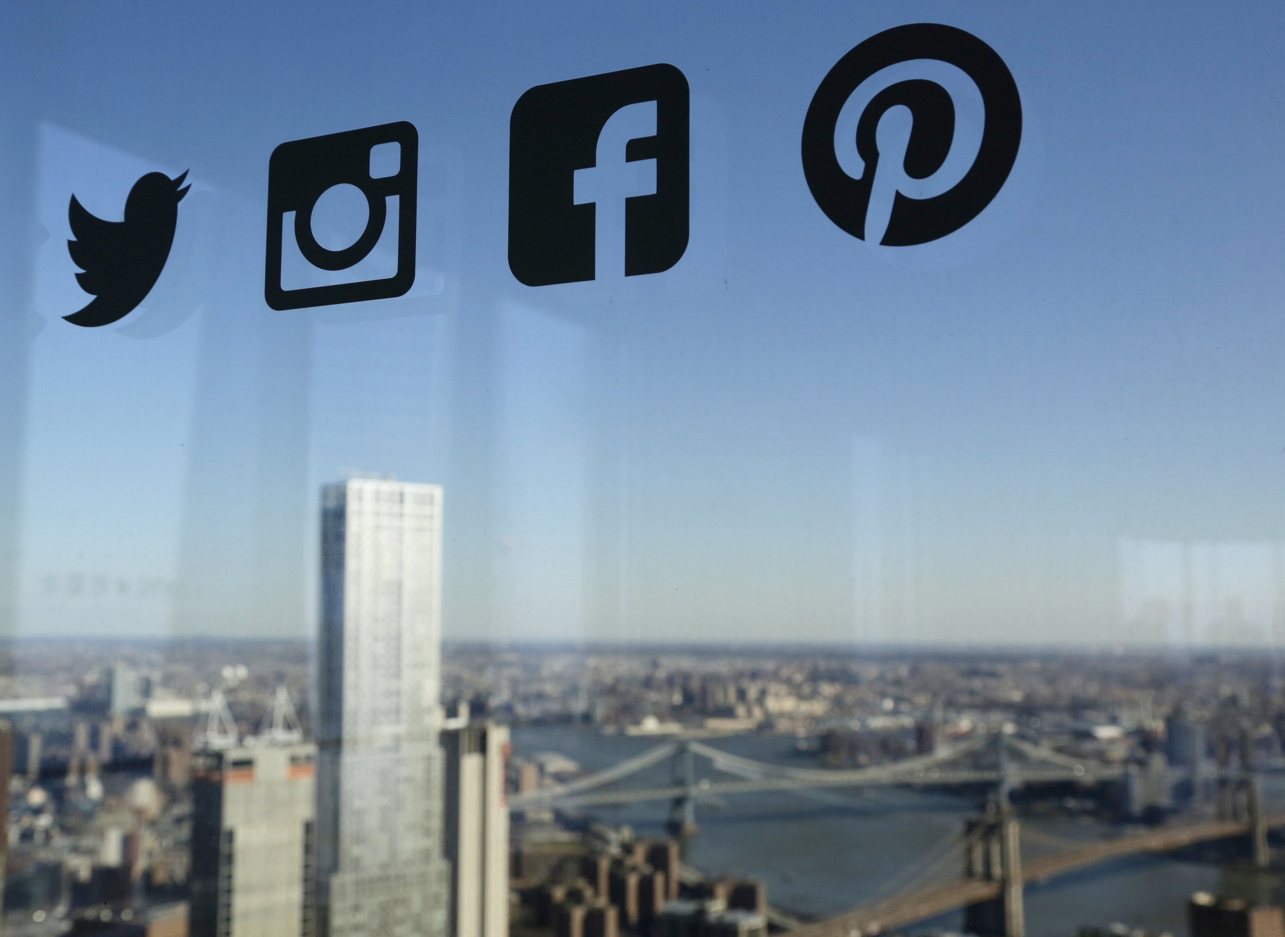 Icons for Twitter, Instagram, Facebook and Pinterest are displayed on a window in New York. Nearly half of U.S. households carry credit card debt, which means many of the friends making you jealous on Instagram may not be able to afford the vacation…