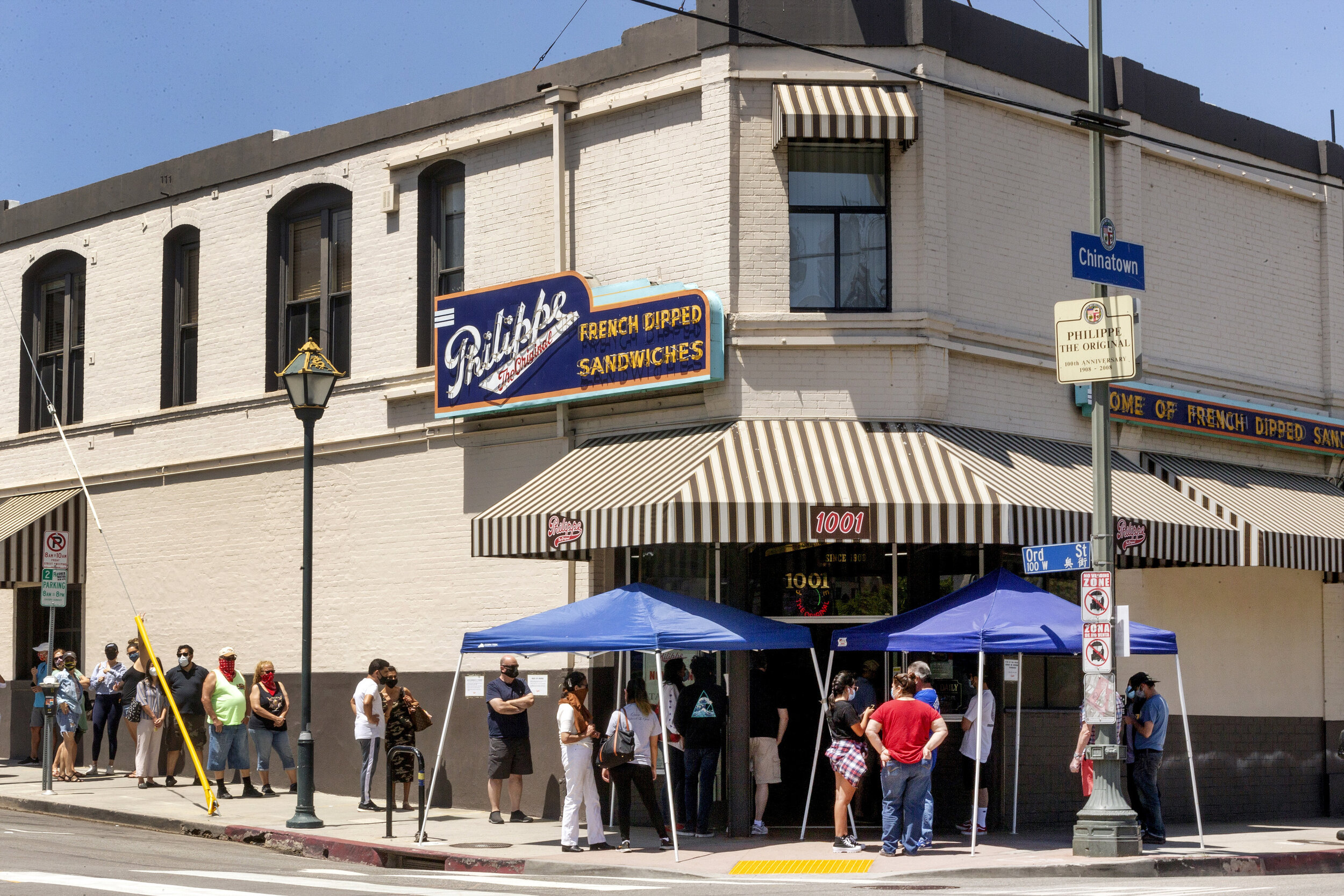 In this Saturday, May 2, 2020 file photo people stand in line while  following social distancing guidelines as they wait for French dip  sandwiches outside Philippe the Original restaurant in downtown Los  Angeles. California restaurants have drafte…