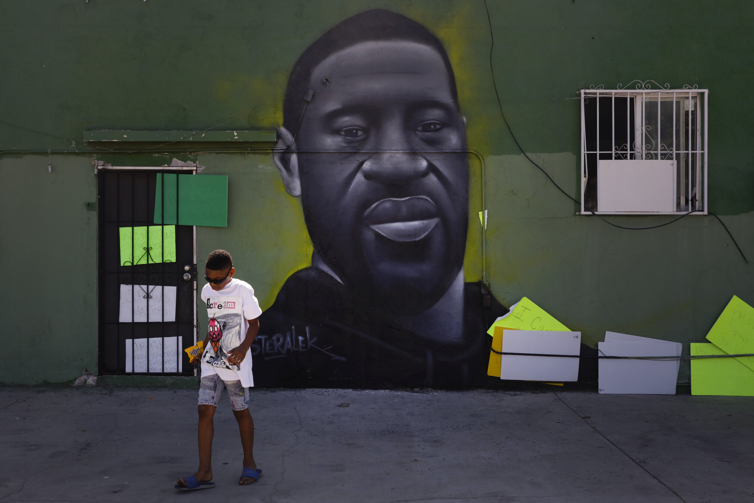  Benjamin Jackson III, 10, walks past a mural depicting George Floyd in the Watts neighborhood of Los Angeles, Tuesday, June 9, 2020. There were no fires this time in Watts. There was no looting, no shooting and no National Guard troops patrolling th