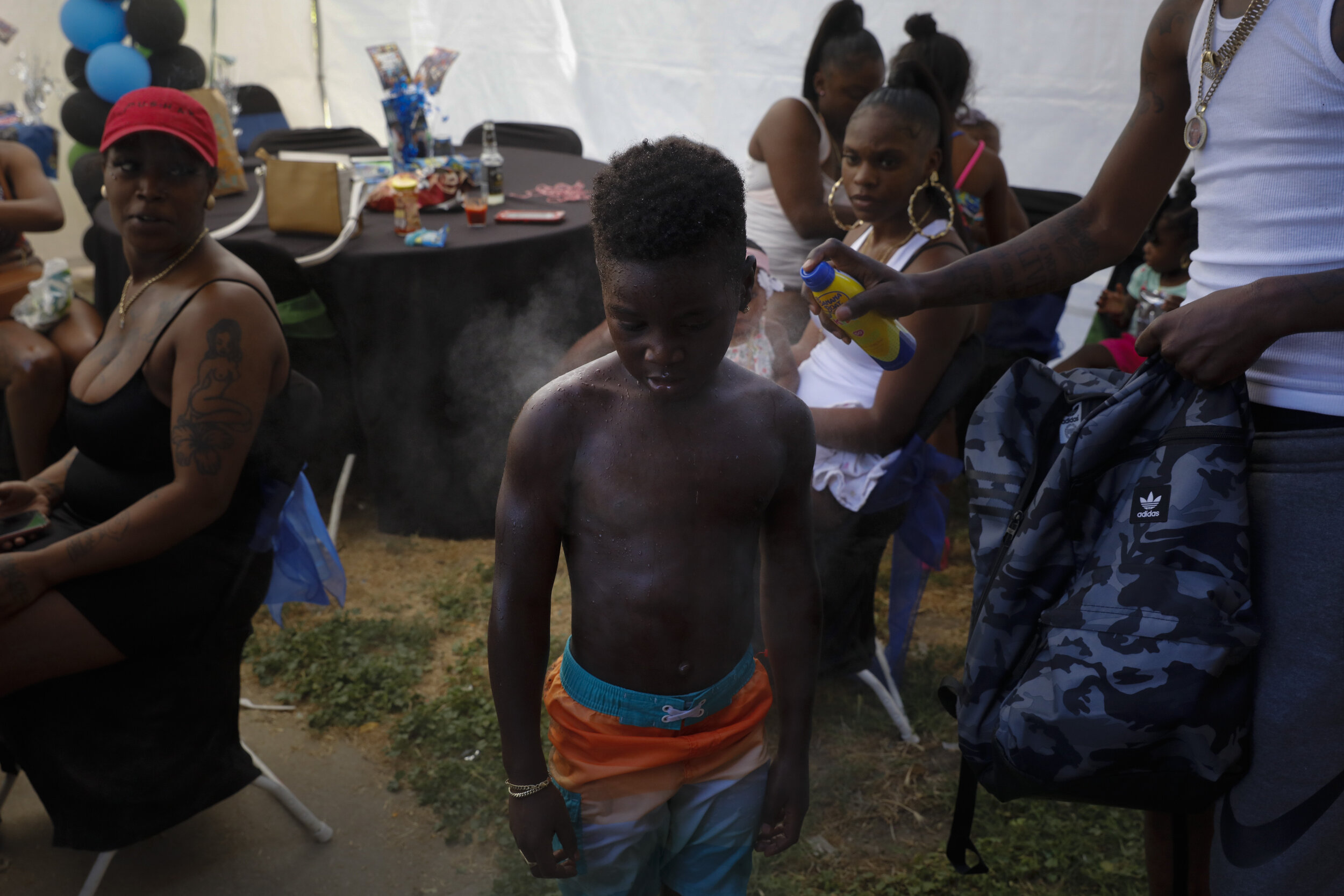  Emmett Palmer, right sprays sunscreen on Iron Grim, 6, as tenants gather for a birthday party at the Nickerson Gardens housing project in the Watts neighborhood of Los Angeles, Wednesday, June 10, 2020. (AP Photo/Jae C. Hong) 