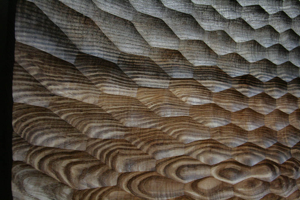 A turned bowl from old ash with an arced facet pattern.