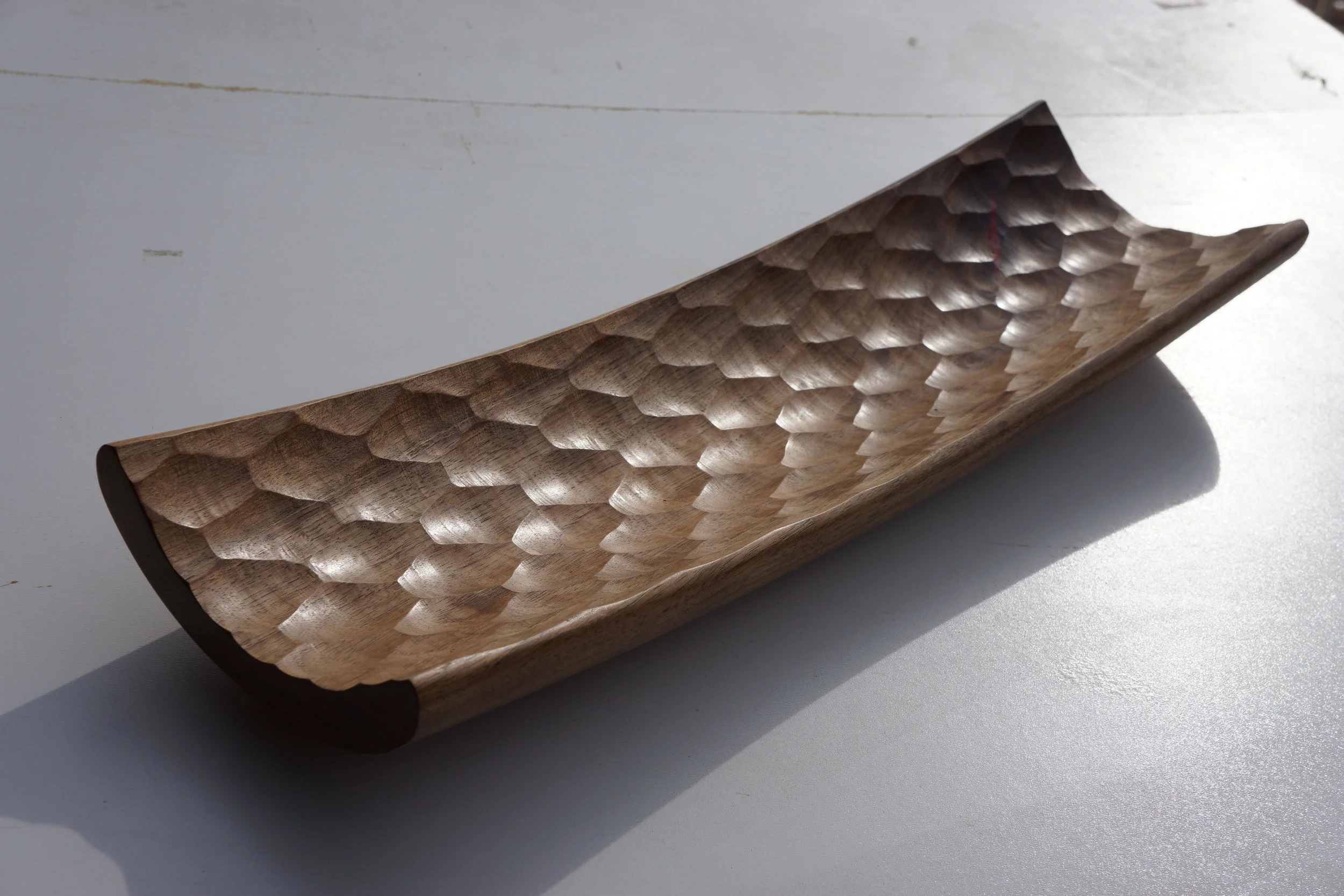  A long faceted walnut vessel. 