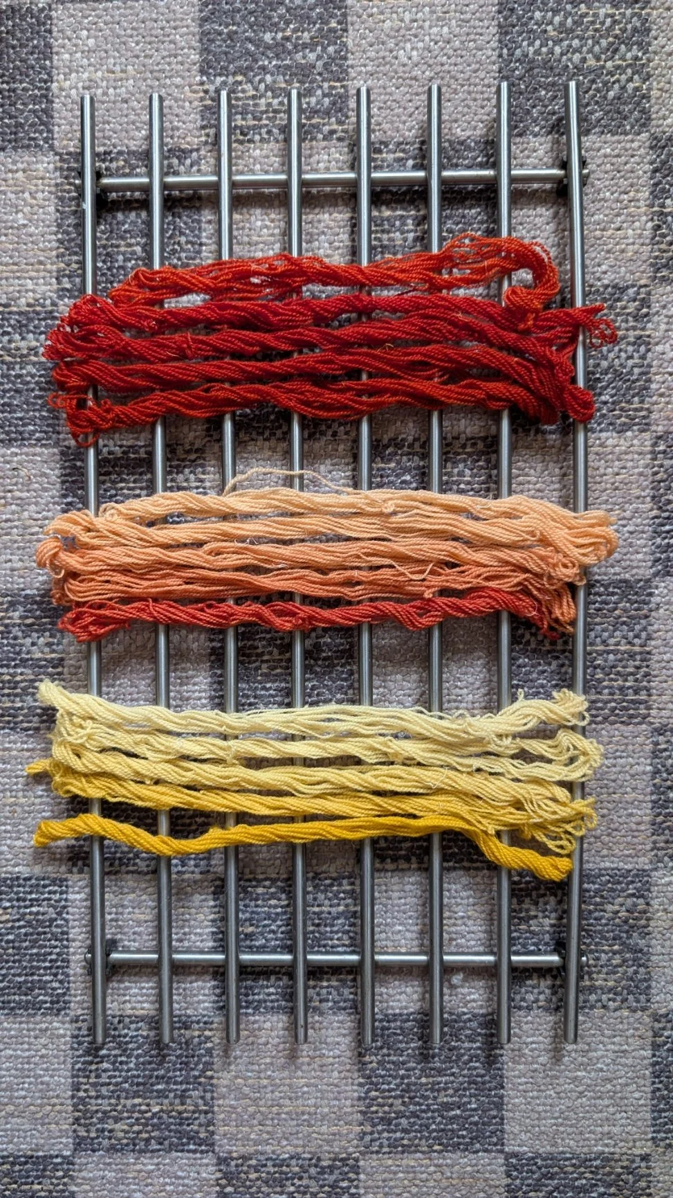 Cream-colored yarn with orange and red streaks, twisted into skeins.