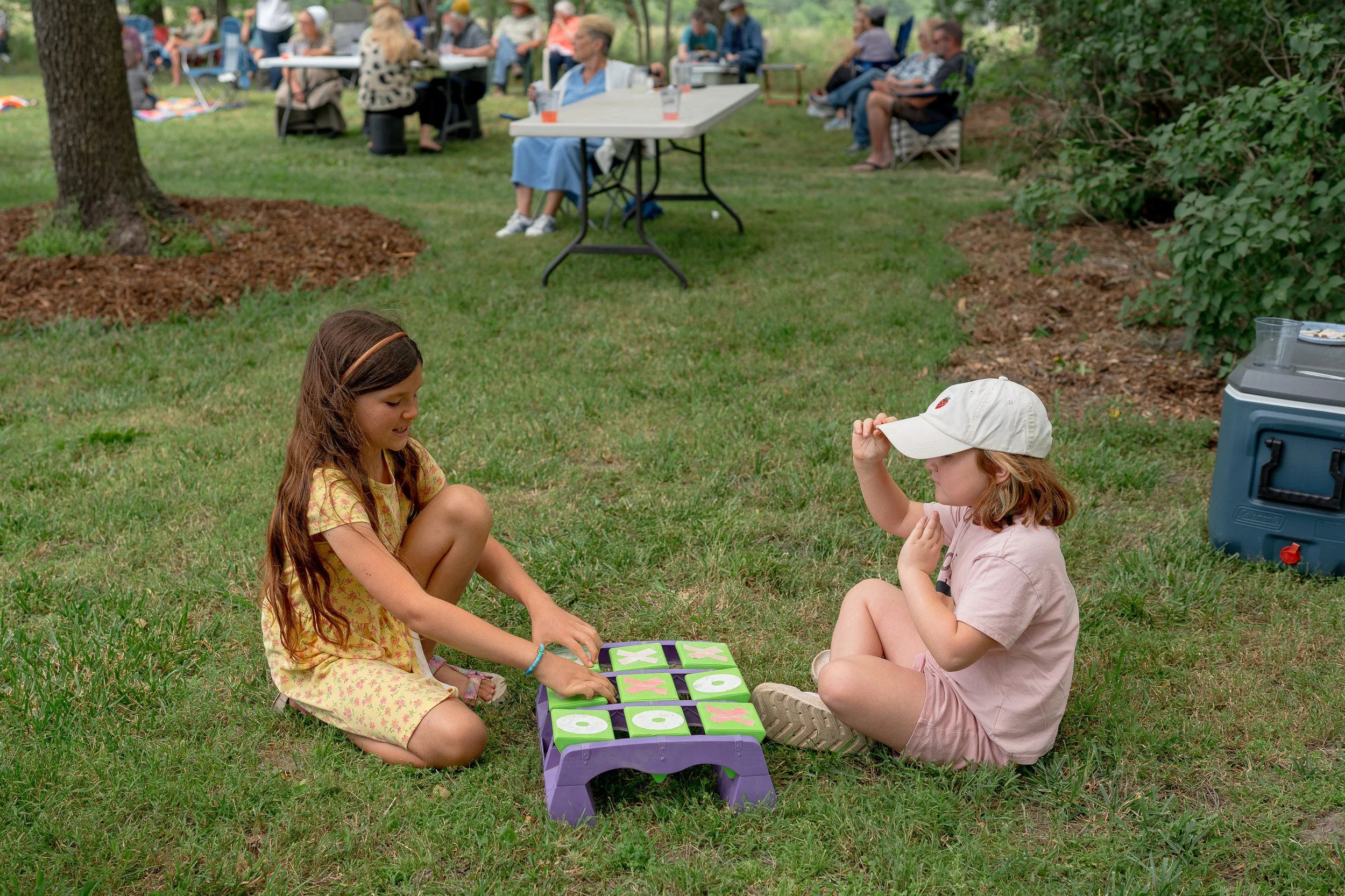 Two girls playing a game in the grass at Farm & Field Day at Peace Valley Poultry