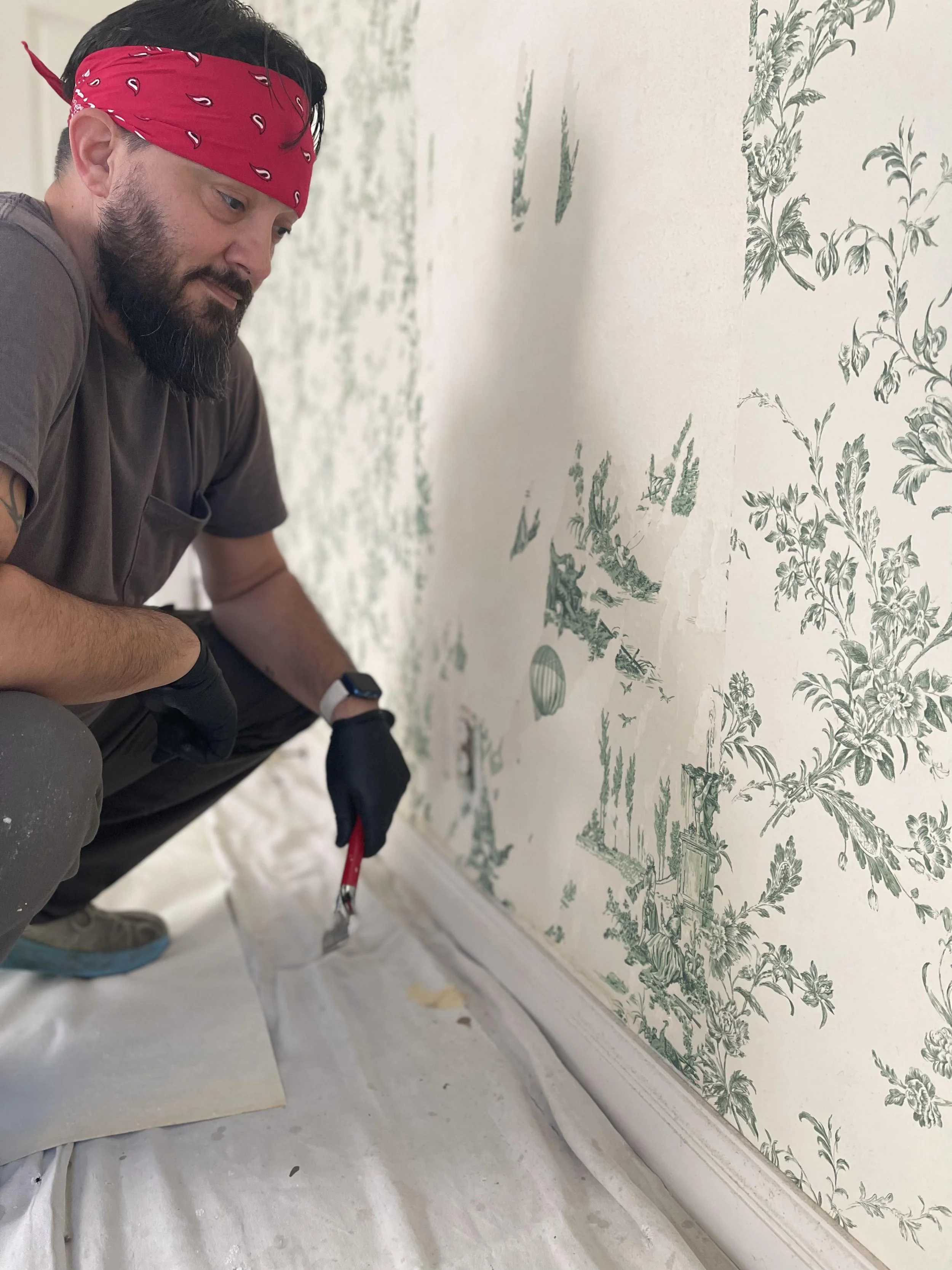 Antonio with The Paper Puller preparing to remove wallpaper from a residential wall