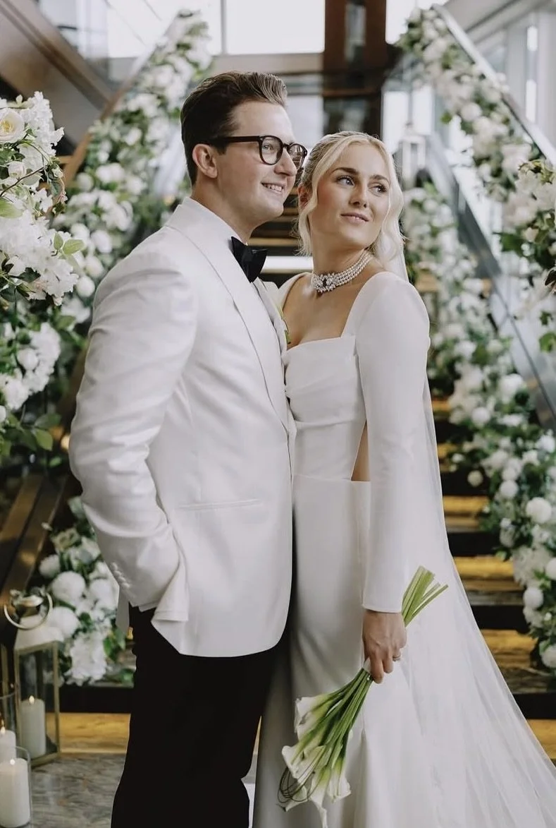 Grand staircase wedding decor at Shangri-La Hotel styled with white florals and lush greenery by Diamond Lush Events.
