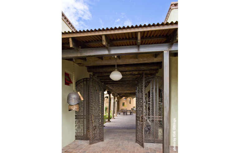 The Milder Home relies on building materials, such as rammed earth and Aerated Autoclaved Concrete (AAC), whose high insulating value maintains comfortable indoor temperatures while conserving energy. The homeowners incorporated recycled wood and and re-sourced architectural elements, such as this iron entry gate from India and “doorbell” gong.