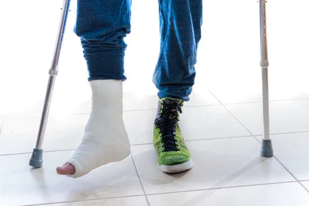 58812946_S_man_cast_crutches_broken_foot_injury_sneaker.jpg