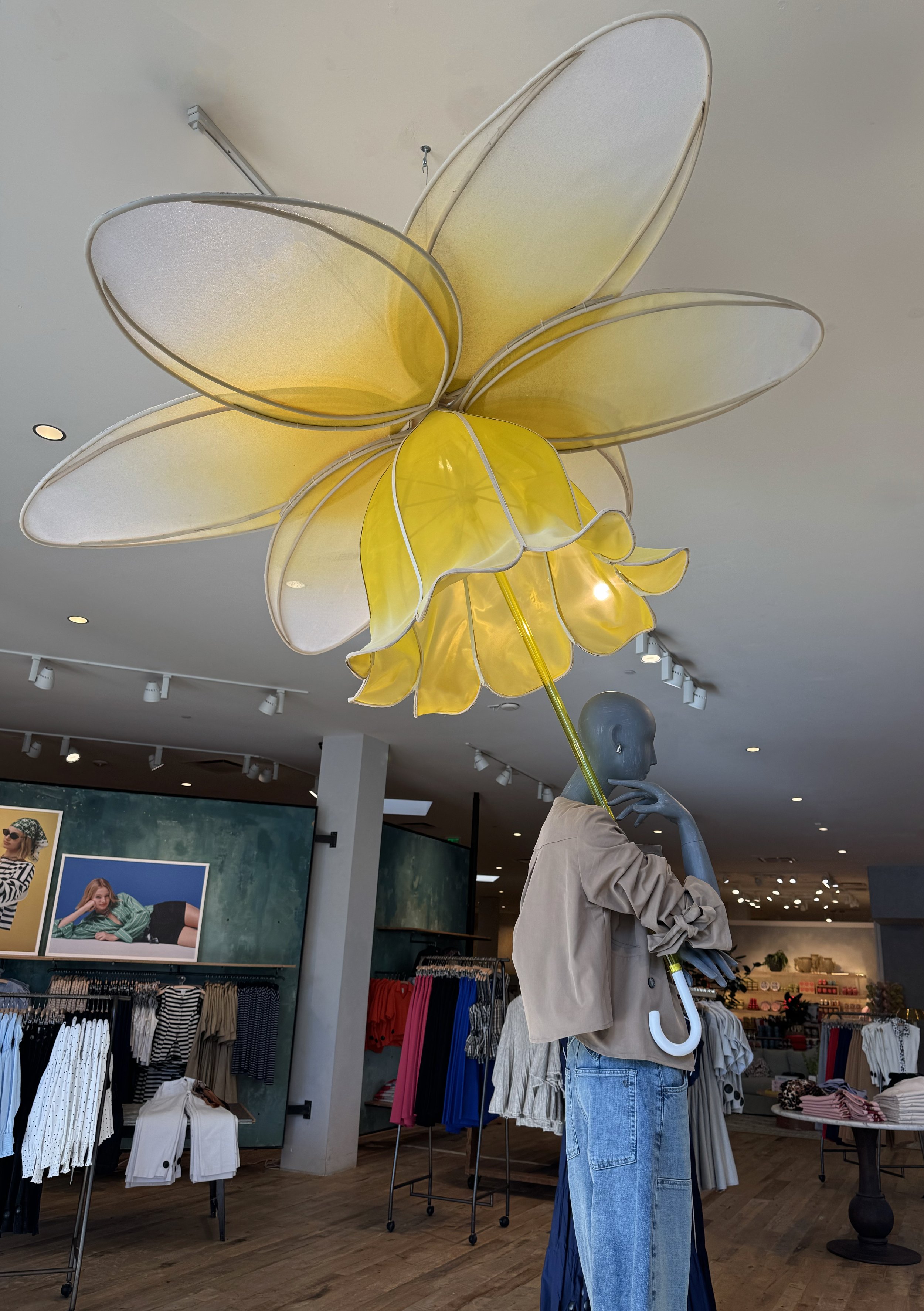    Anthropologie Spring ‘26 Interiors:    Daffodil umbrella made from painted silk screen, and soaked reed. Lit frosted risers, filled with hand dyed flowers . 