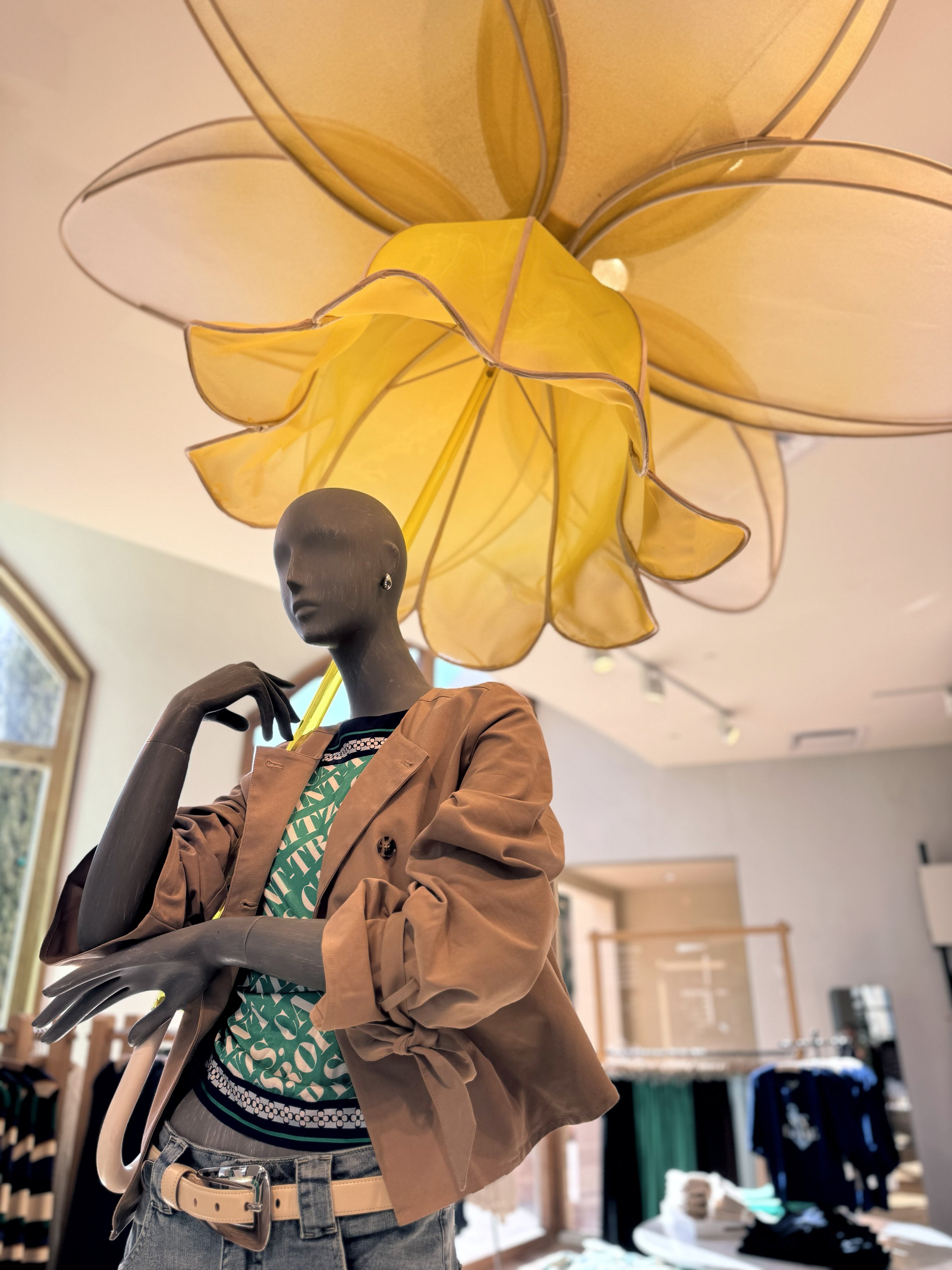    Anthropologie Spring ‘26 Interiors:    Daffodil umbrella made from painted silk screen, and soaked reed. Lit frosted risers, filled with hand dyed flowers . 