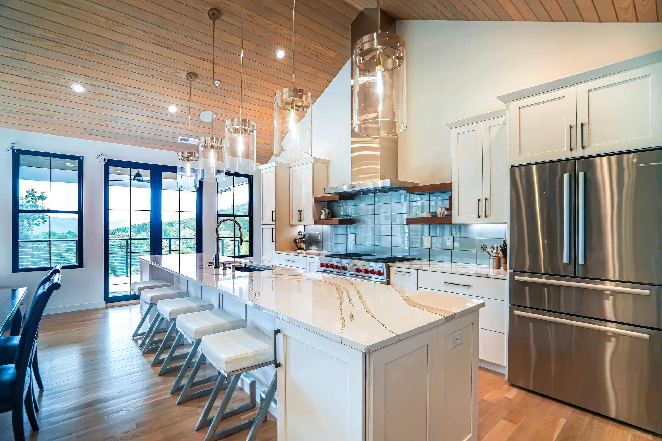 Custom kitchen with white shaker cabinets, a full-length Cambria Quartz island, and a custom tile backsplash in a Hendersonville, NC home by HomeSource Design Center