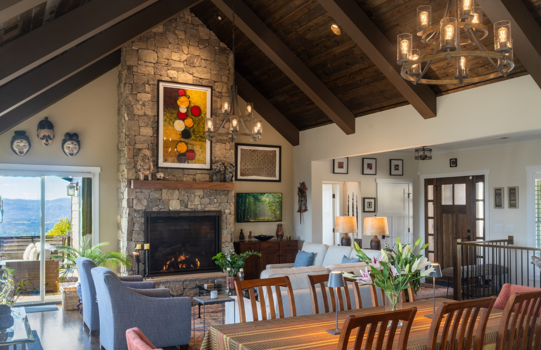 Floor-to-ceiling stacked stone fireplace with wood mantel in a vaulted mountain home living room