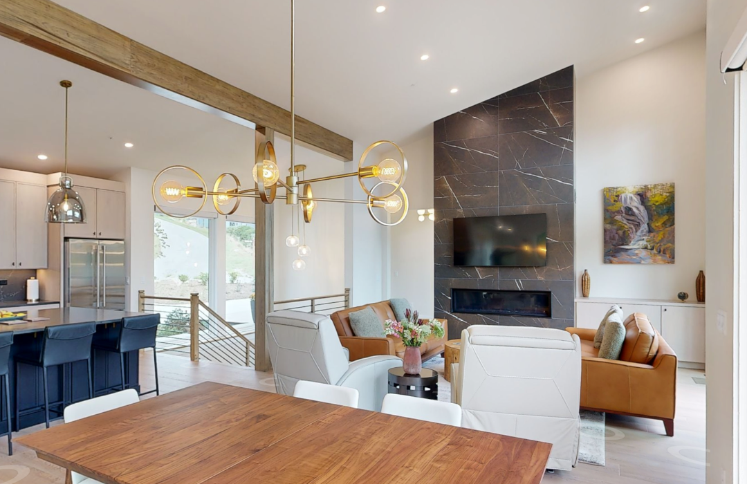 Floor-to-ceiling dark stone fireplace surround in an open great room with vaulted ceiling