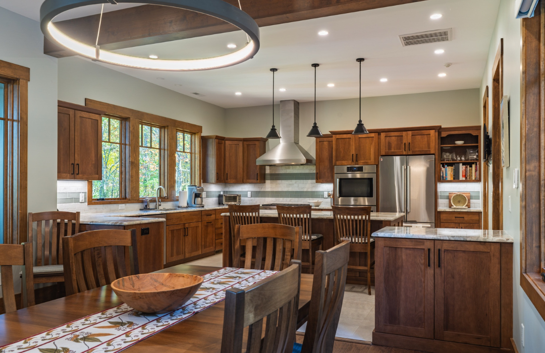 Cherry wood kitchen cabinets paired with light countertops and sage green walls showing how to mix wood tones with complementary materials