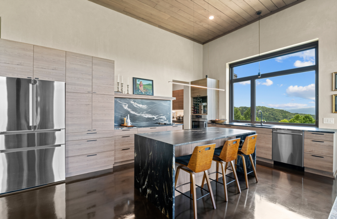 Kitchen with mountain views, dark stone island, and light wood cabinetry