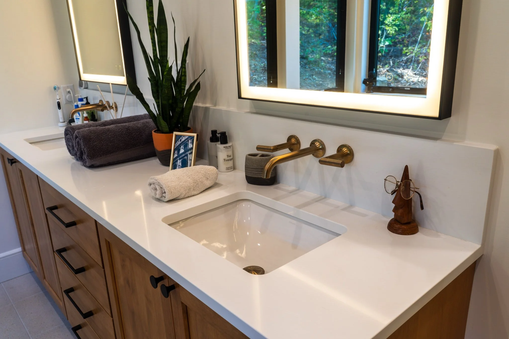homesource-primary-bath-wood-vanity-white-quartz-brass-wall-mount-faucet.jpg