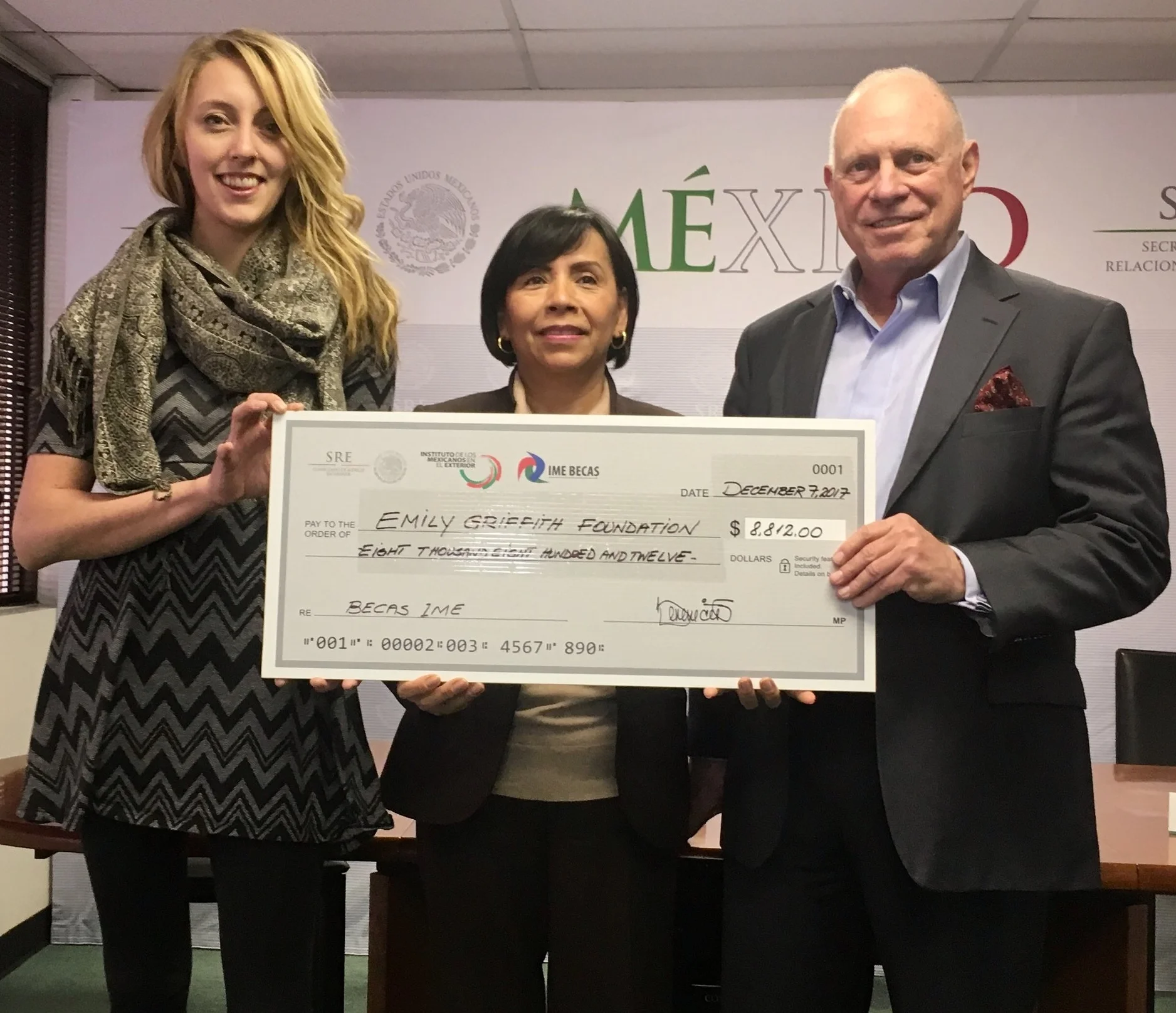 Emily Griffith Foundation's Development Officer, Serena Vandenberg (left), and President, Alby Segall, receive a check for scholarships from the Consul General of Mexico, Berenice Rendón Talavera (center).