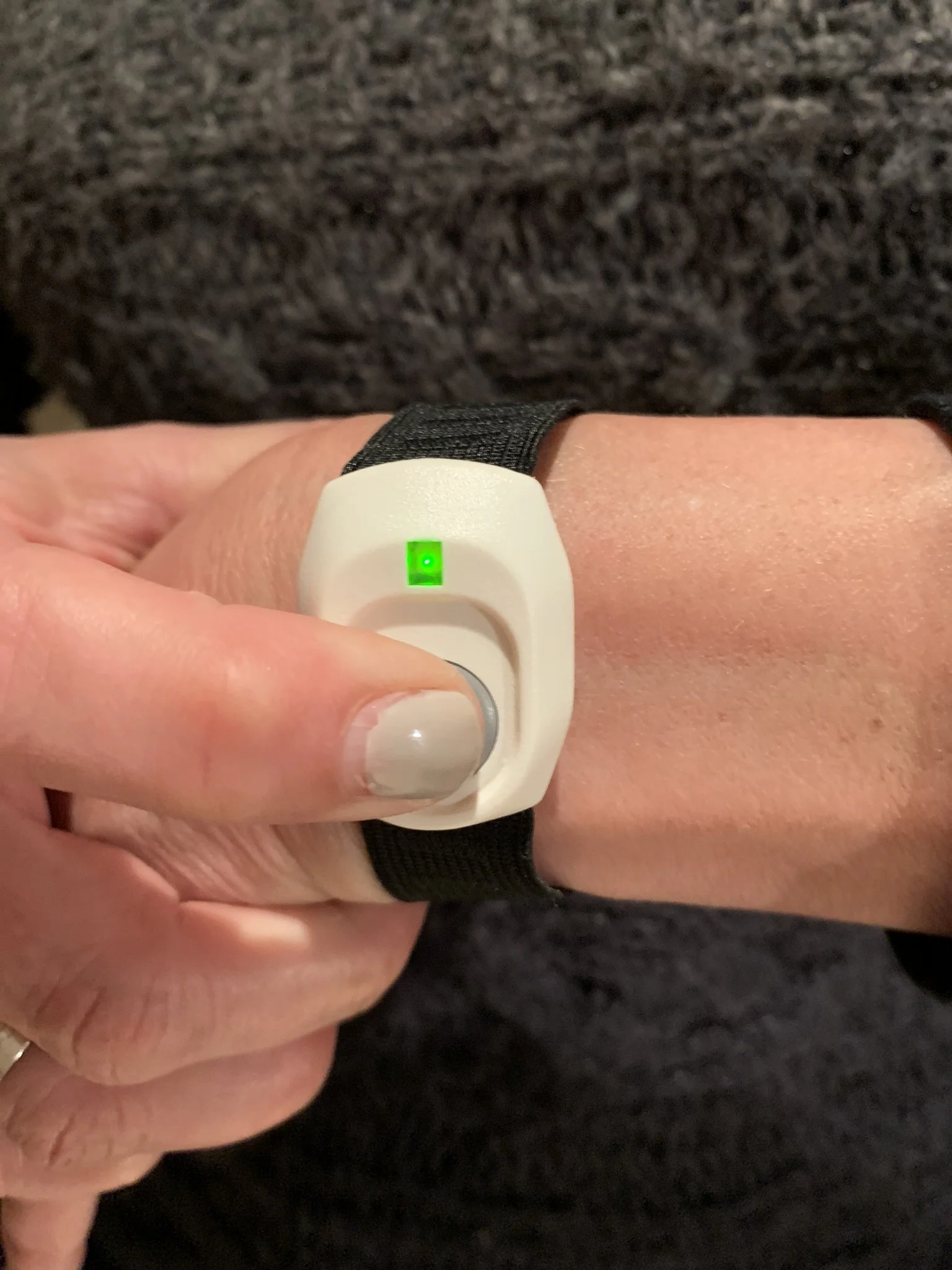 Person pressing wrist-worn Cellular Home Link emergency button