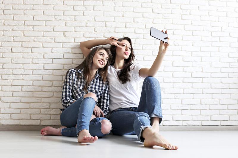 portrait-two-millennial-females-fooling-around-front-mobile-smartphone-camera-brown-eyed-model-girls-long-brunette-108808573.jpg