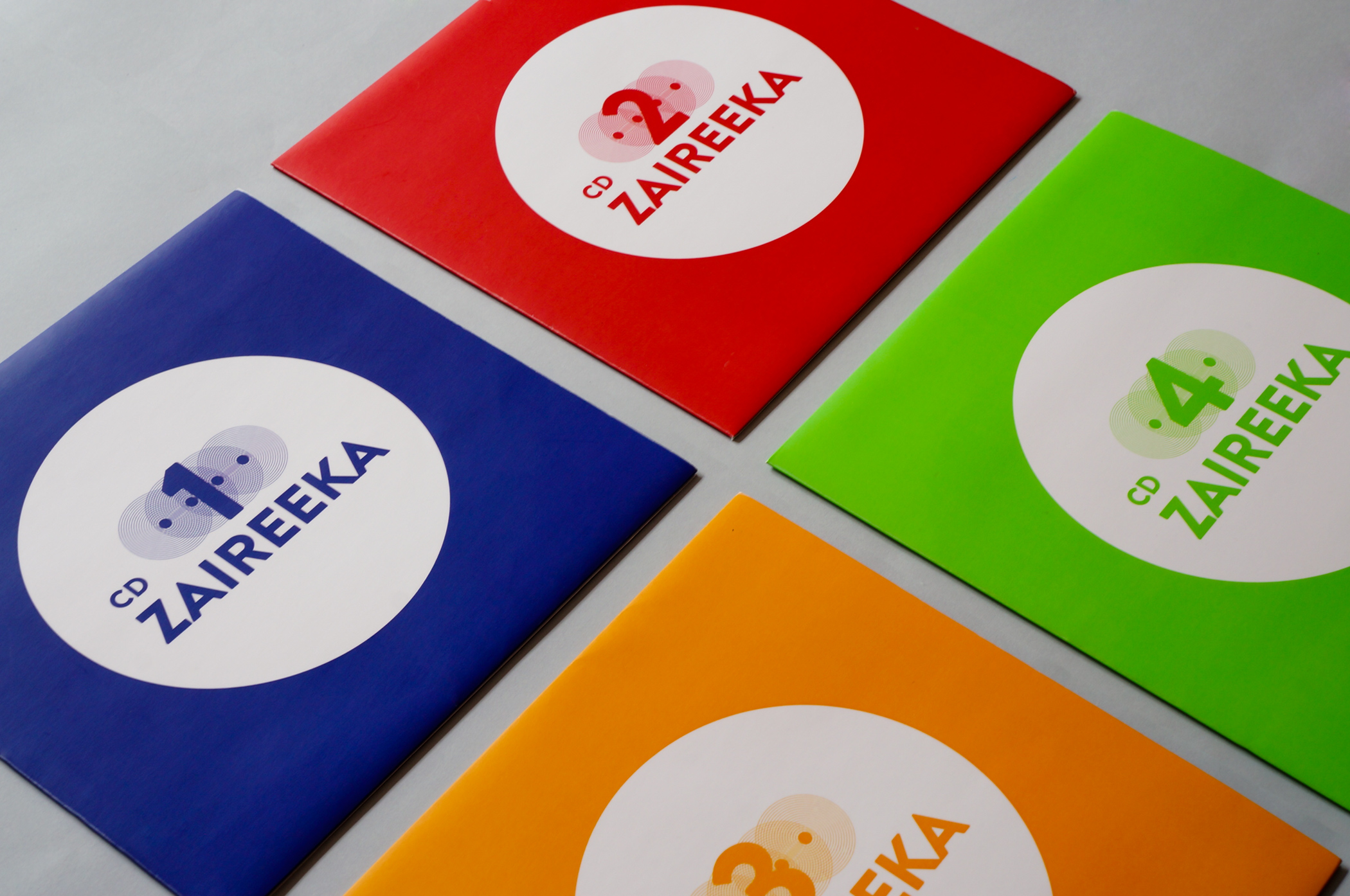 Four envelopes containing geometric drawings which represent the songs and are arranged in the same way as the discs in the album.
