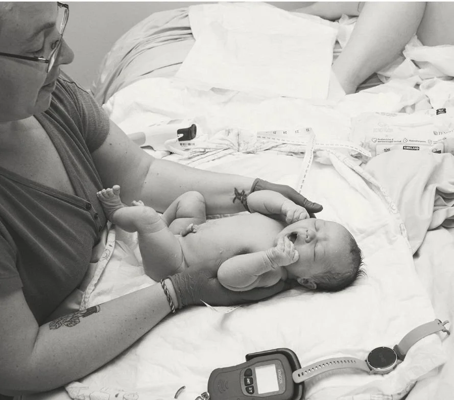 midwife checking the health of a newborn baby