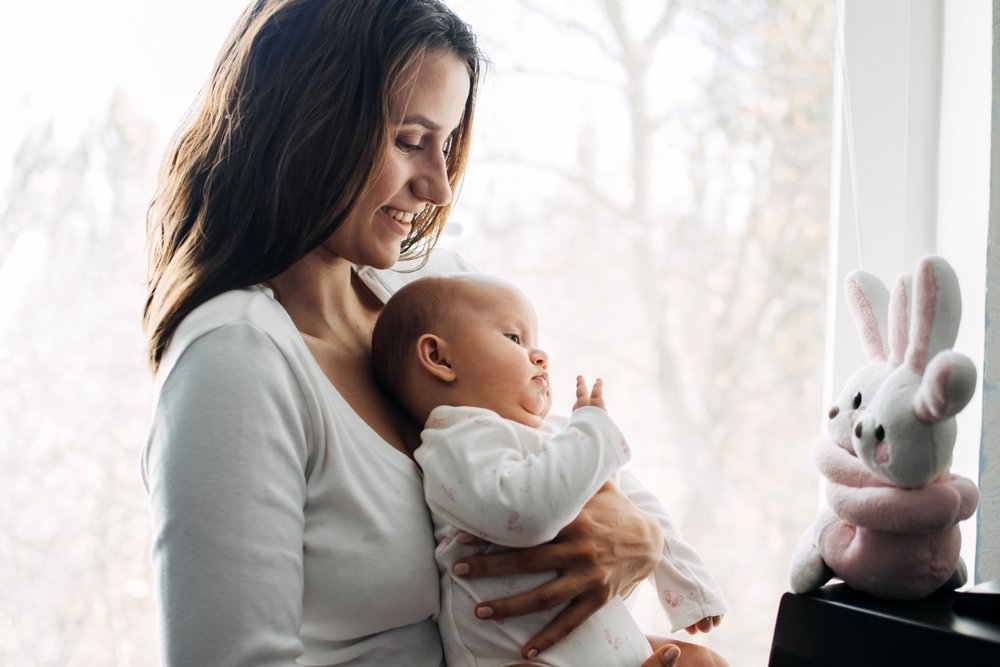 mom smiling while holding her baby
