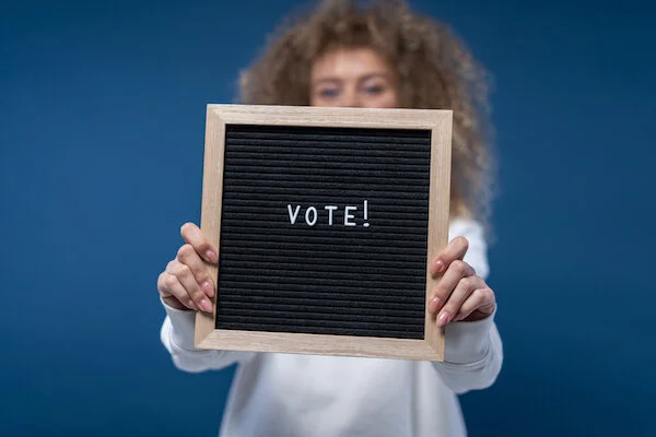 Canva - Person Holding a Vote Sign.jpg