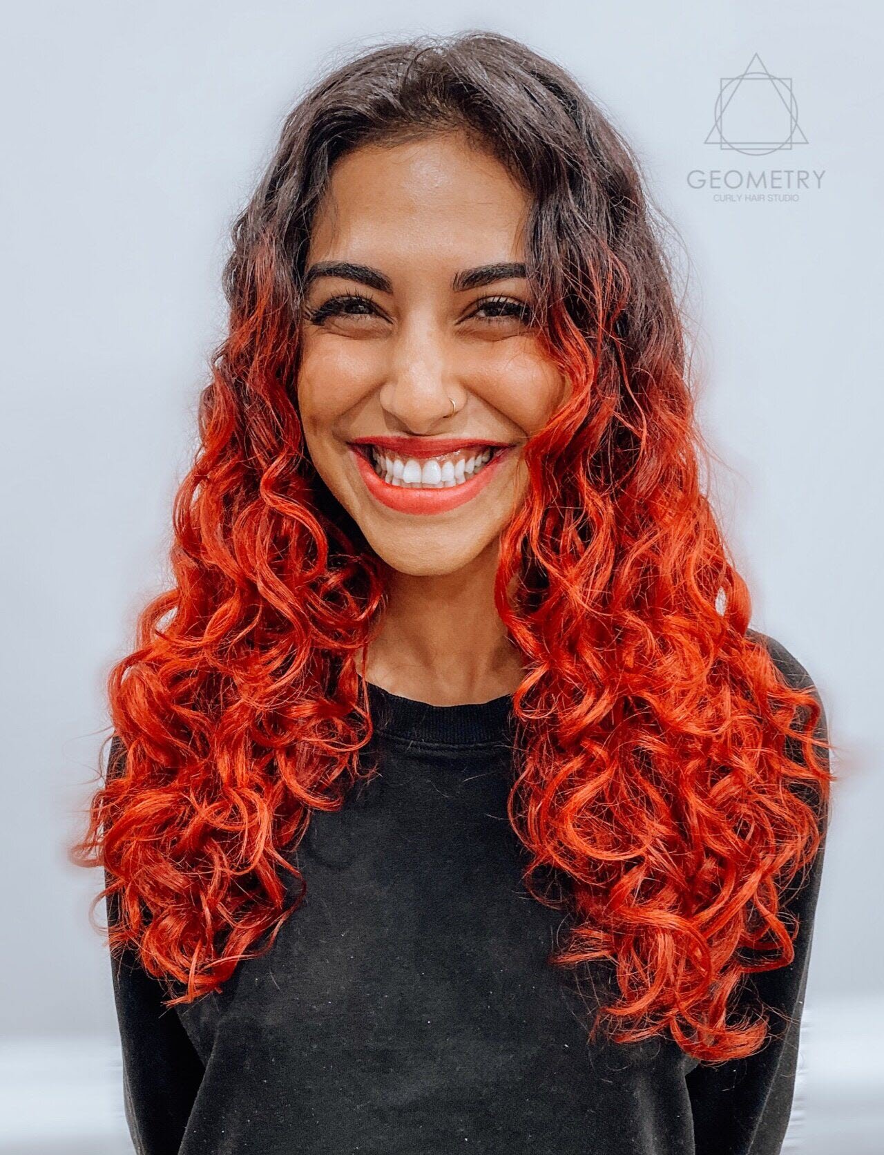 Vibrant long red curly hair cut and custom color